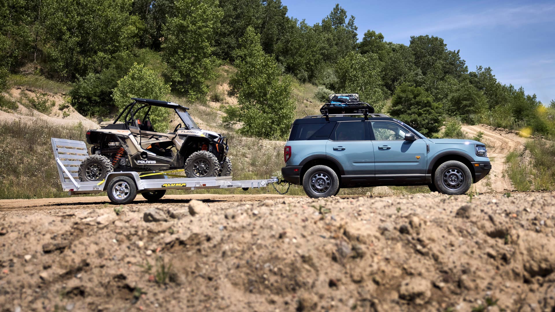 Bronco Sport TOW RZR. TOW RZR matches the added passenger comfort and technology features of the Badlands series with towing and cargo accessories to help adventurers haul more outdoor gear. The custom build adds Yakima HD Bar crossbars and OffGrid medium cargo basket and Class II Trailer Tow Package with 2,200 pounds of capacity to tow off-road runners like the all-new Polaris® RZR XP Turbo 1000™, unveiled today as part of the Bronco birthday celebration. (Preproduction image with optional features shown. Available late 2020.)