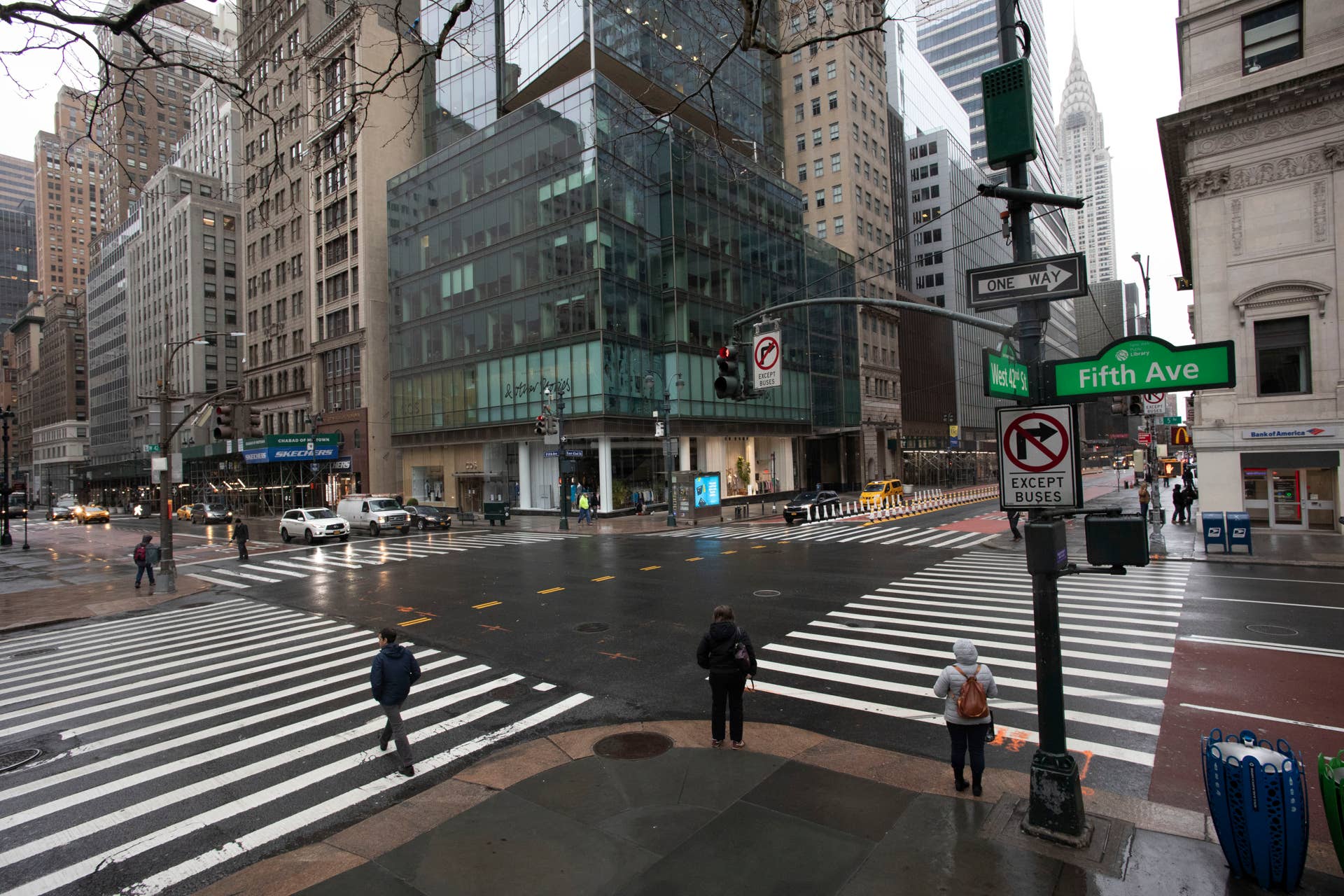 Commuters are in the intersection of Fifth Ave. and 42nd Street, which is normally very crowded on a weekday morning, Monday, March 23, 2020 in New York. Gov. Andrew Cuomo has ordered most New Yorkers to stay home from work to slow the coronavirus pandemic. (AP Photo/Mark Lennihan)
