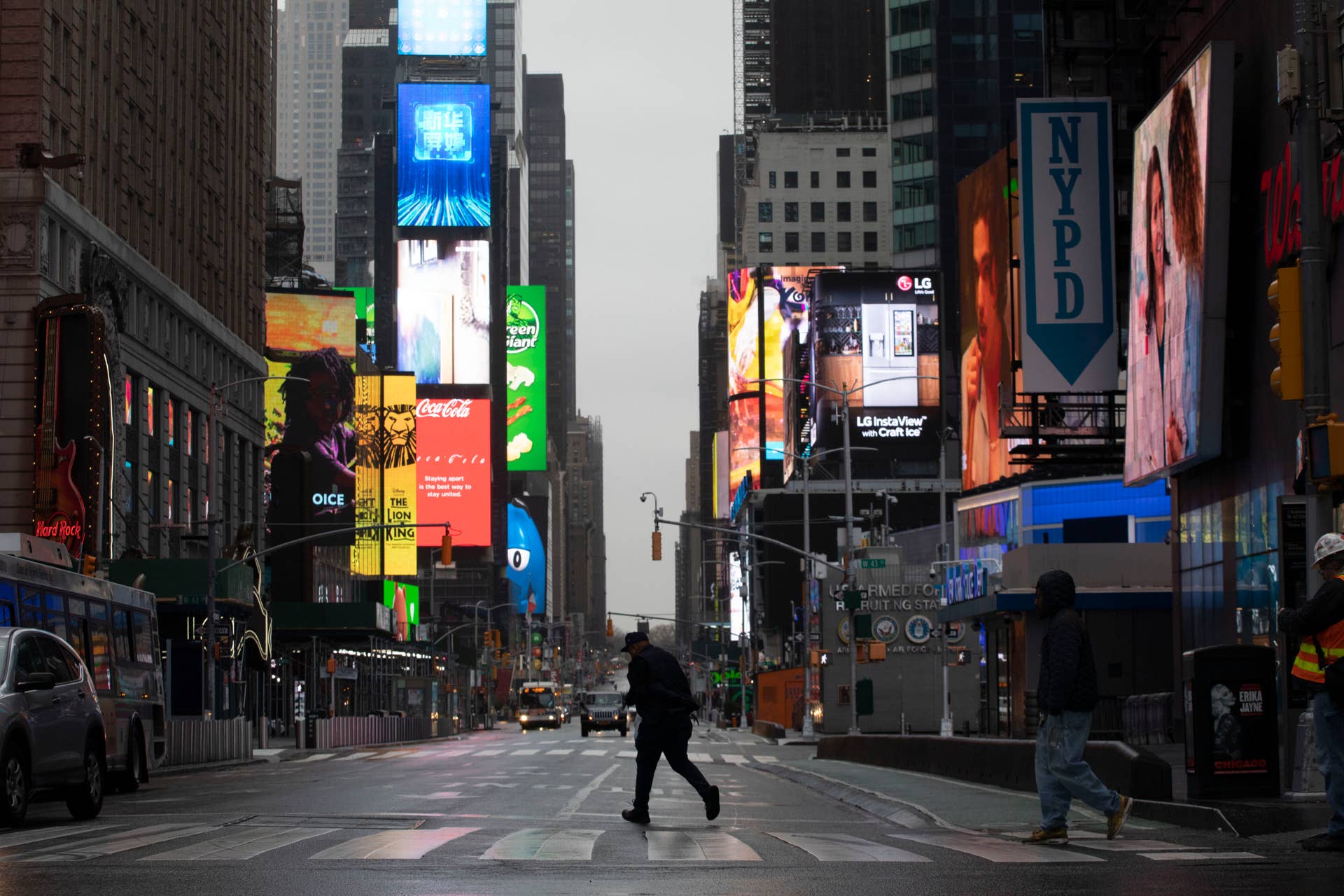 A man walks through a nearly empty Times Square, which is usually very crowded on a weekday morning, Monday, March 23, 2020 in New York. Gov. Andrew Cuomo has ordered most New Yorkers to stay home from work to slow the coronavirus pandemic. (AP Photo/Mark Lennihan)
