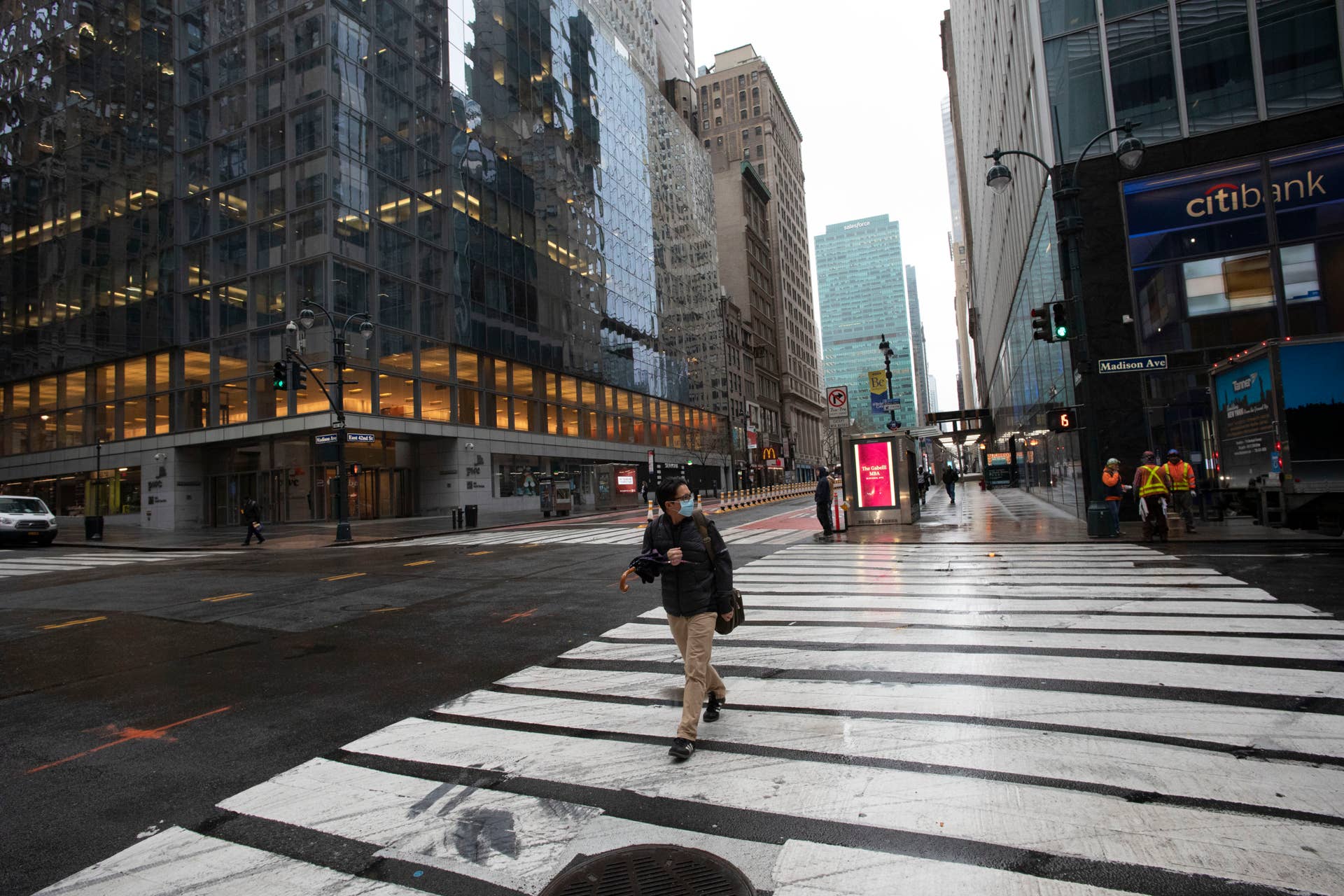 A commuter crosses Madison Ave., Monday, March 23, 2020 in New York. Gov. Andrew Cuomo has ordered most New Yorkers to stay home from work to slow the coronavirus pandemic. (AP Photo/Mark Lennihan)