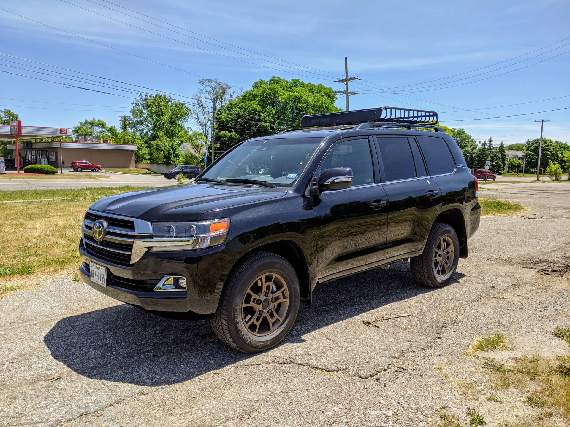 The Toyota Land Cruiser features a large roof rack. 18-inch BBS wheels and special badging.