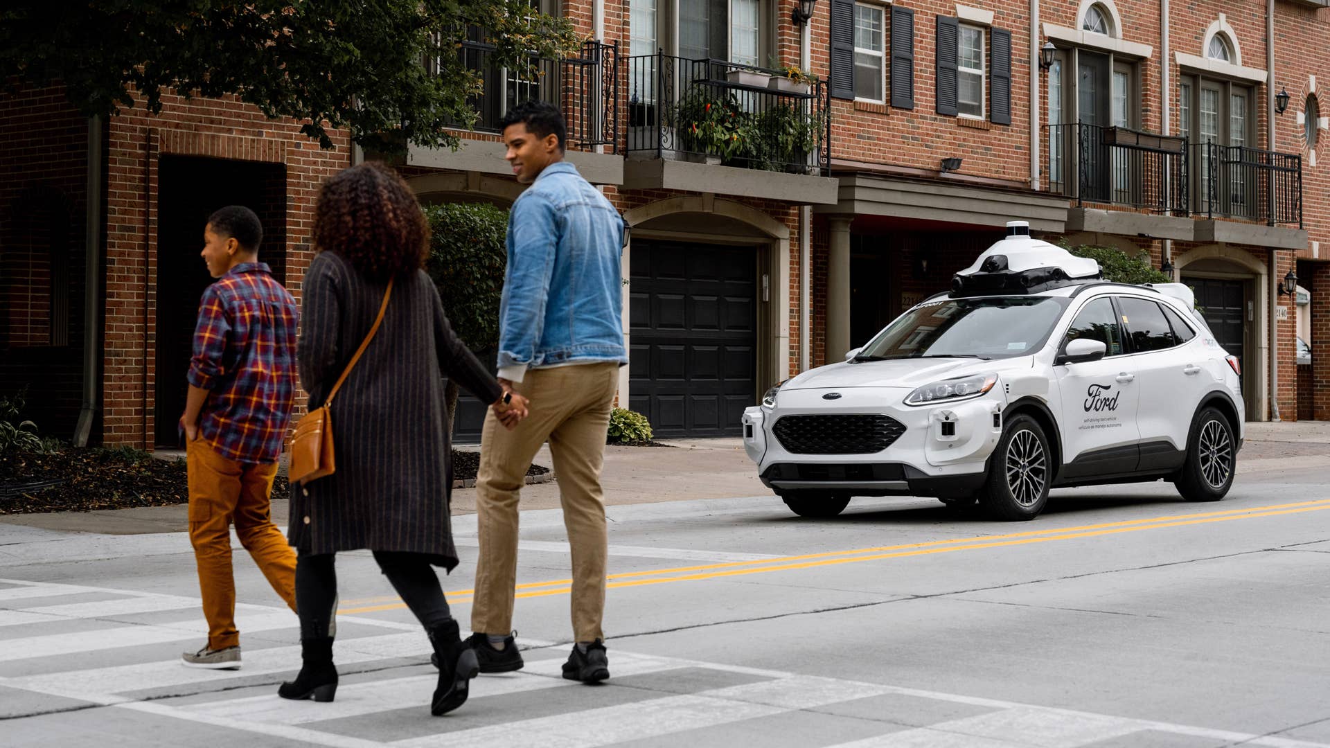 A Ford self-driving test vehicle stops to allow pedestrians to pass.