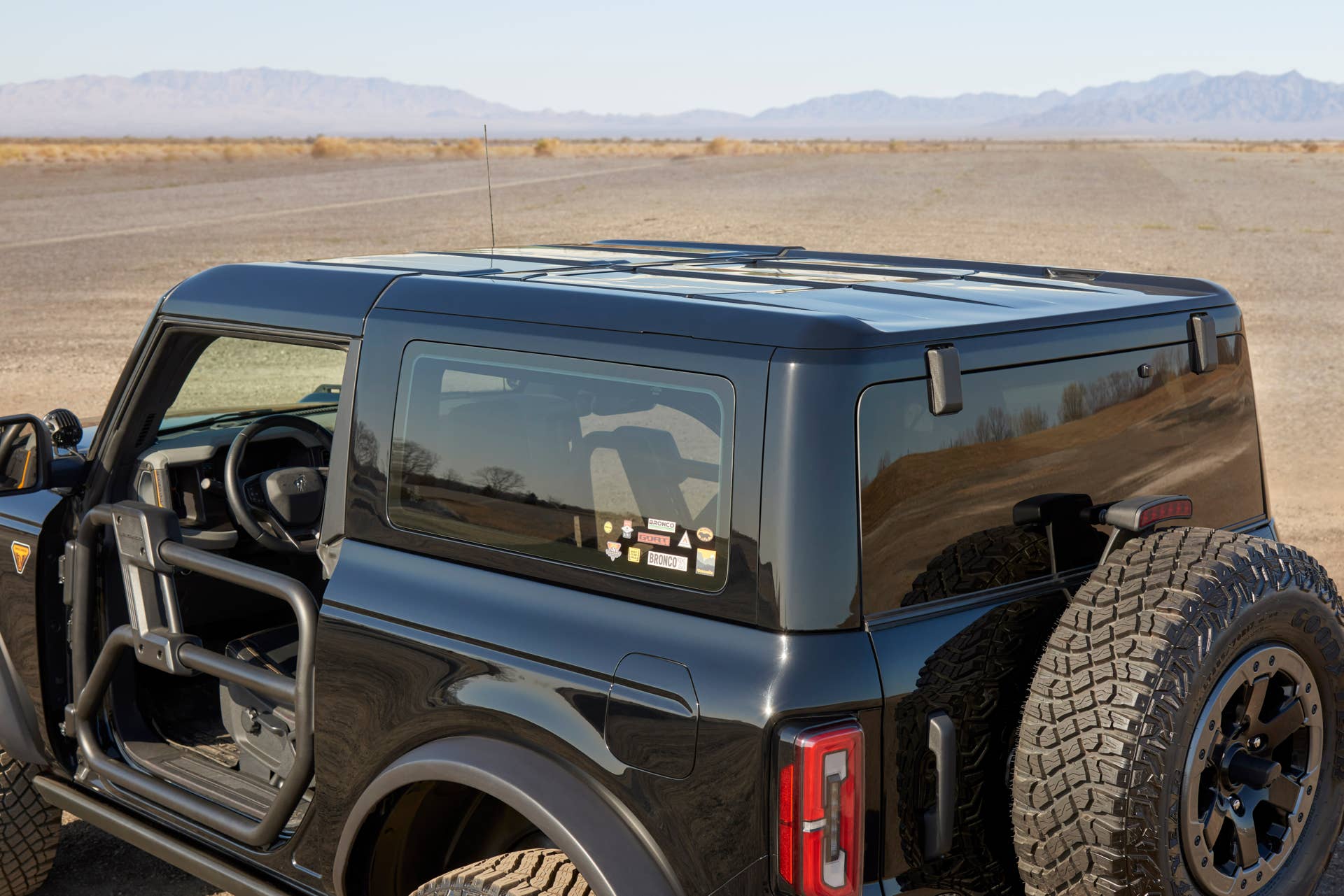Close up of Bronco two-door Badlands in Shadow Black with black painted modular hard top. Two door modular hard tops have removable opening over second row and removeable rear side glass. These features are not available on the MIC hardtop. The Modular Painted Hardtop will be available in the 2022 model year.