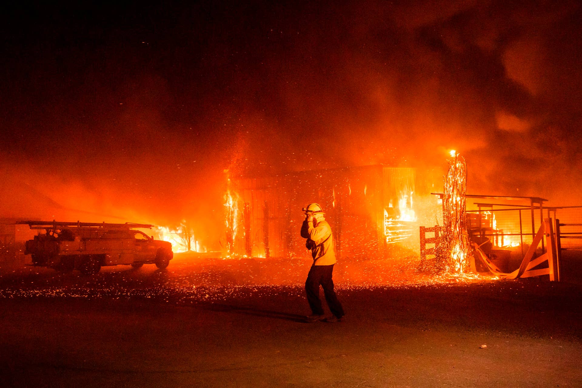 Firefighters battle a wind-driven fire burning structures on a farm during the Kincade fire in Windsor, California on October 27, 2019. - California's governor declared a state-wide emergency on October 27 as a huge wind-fueled blaze forced evacuations and massive power blackouts, threatening towns in the famed Sonoma wine region. (Photo by Philip Pacheco / AFP) (Photo by PHILIP PACHECO/AFP via Getty Images)
