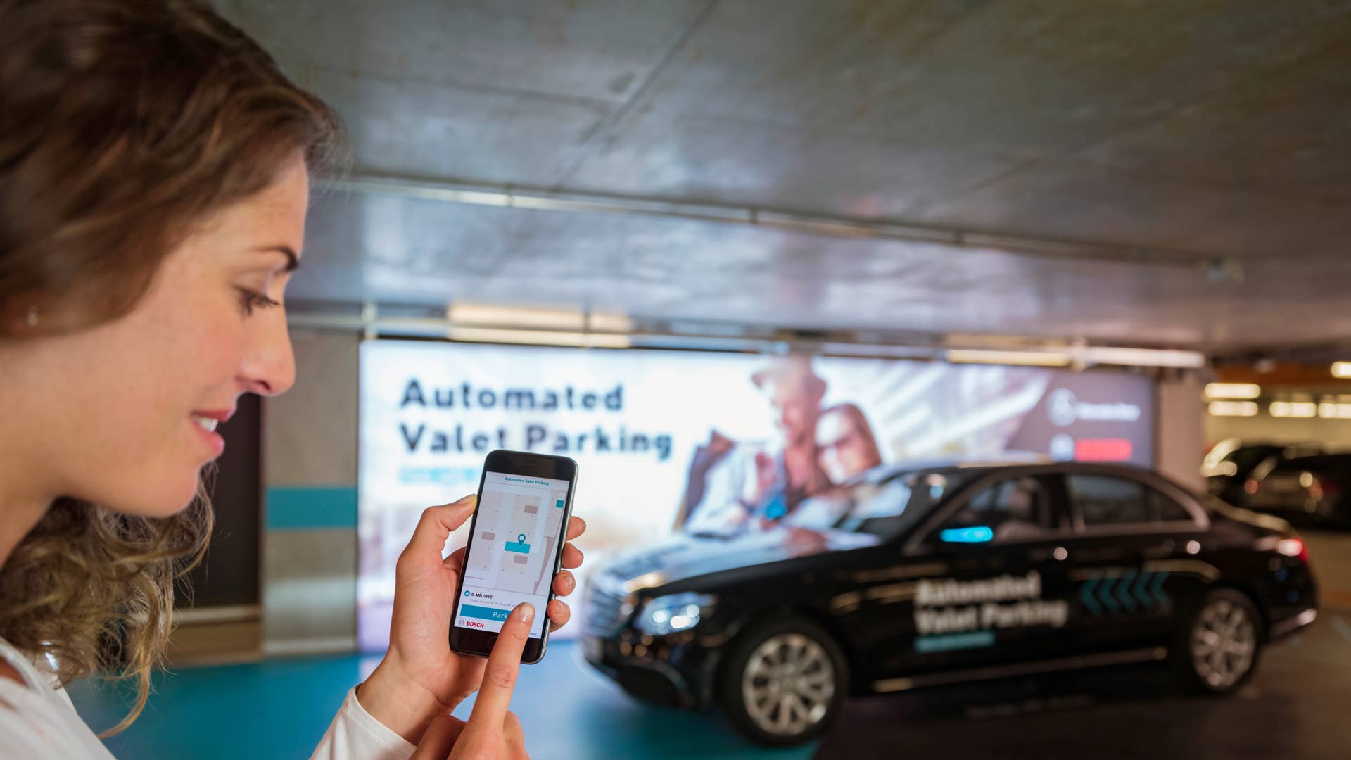 Fahrerloses Parken im realen Verkehr: Weltpremiere im Parkhaus des Mercedes-Benz Museums. Per Smartphone-Befehl fahren Autos fahrerlos in einen zugewiesenen Stellplatz, ohne dass der Fahrer das Manöver noch überwachen muss. Möglich wird das fahrerlose Parken mithilfe einer intelligenten Parkhaus-Infrastruktur von Bosch im Zusammenspiel mit der Fahrzeugtechnik von Mercedes-Benz. Driverless parking in real-life traffic: World premiere in the multi-storey car park of the Mercedes-Benz Museum. Cars proceed without a driver to an assigned parking space in response to a command issued by smartphone, without any need for the driver to supervise the manoeuvre. Driverless parking is made possible by an intelligent multi-storey car park infrastructure from Bosch in conjunction with the vehicle technology from Mercedes-Benz.
