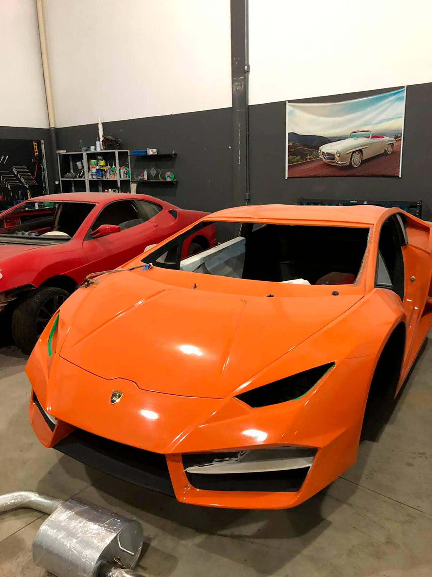 This July 15, 2019 photo released by Itajai Civil Police shows luxury car replicas inside a workshop in Itajai, Brazil. Brazilian police dismantled the clandestine workshop run by a father and son who assembled fake Ferraris and Lamborghinis to order, in Brazil's southern state of Santa Catarina. (Itajai Civil Police via AP)