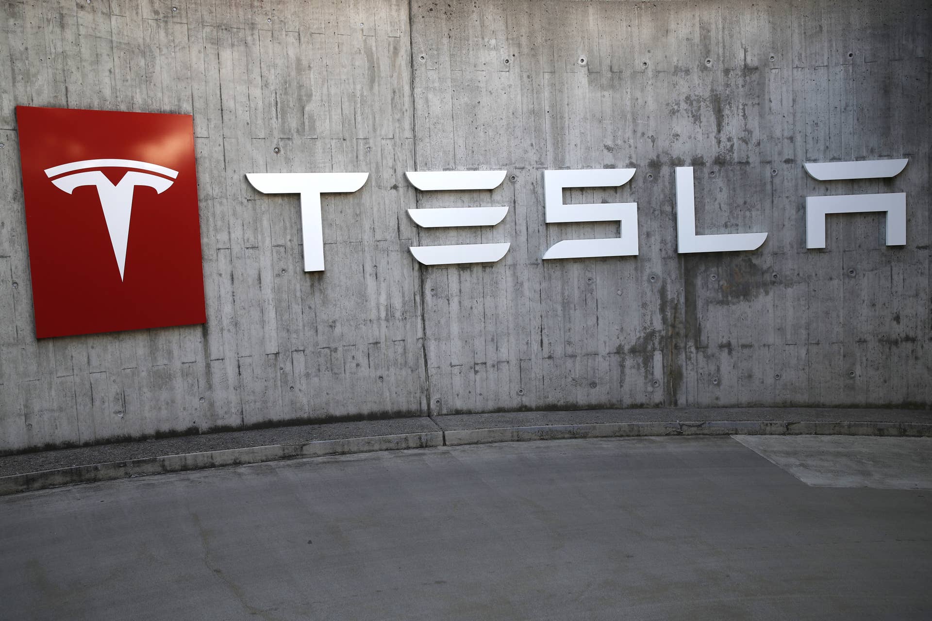 A company logo hangs outside a Tesla Inc. store in Bern, Switzerland, on Thursday, Aug. 16, 2018. Tesla chief executive officer Elon Musk�has captivated the financial world by blurting out via Twitter�his�vision of transforming�Tesla�into a private company. Photographer: Stefan Wermuth/Bloomberg via Getty Images