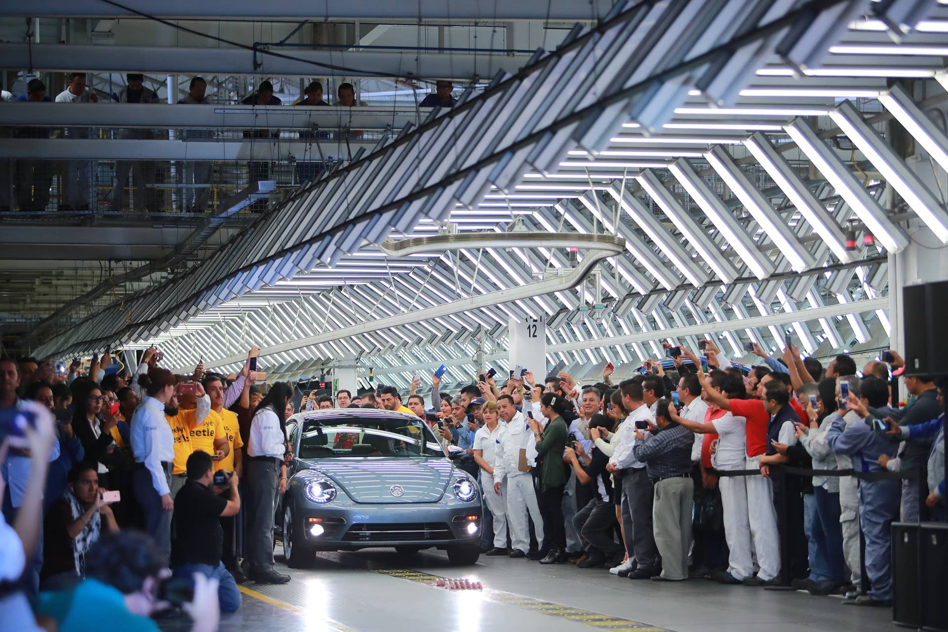 CUAUTLANCINGO, MEXICO - JULY 10: Volkswagen's last Beetle produced is displayed while people take photos of it during a ceremony to announce the cease of the production of the VW Beetle after 21 years in the market, at Volkswagen Plant on July 10, 2019 in Cuautlancingo, Mexico. Considered as the successor of the Volkswagen Type 1, the Beetle was produced during 21 years in the Cuautlancingo plant, it is estimated that over 17 millions of units were produced. (Photo by Hector Vivas/Getty Images)