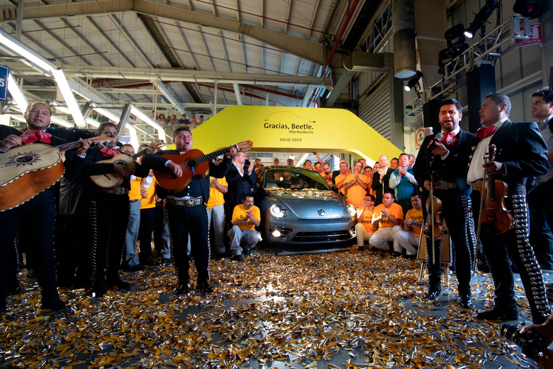 Volkswagen employees pose with a "Beetle", the final edition of the iconic car, at a factory in Puebla, Puebla State, Mexico, on July 10, 2019. - The bug-shaped metallic blue sedan rolled off the production line in central Mexico to rapturous applause, the last of a model first manufactured in the late 1930s. (Photo by JUAN CARLOS SANCHEZ / AFP)        (Photo credit should read JUAN CARLOS SANCHEZ/AFP/Getty Images)