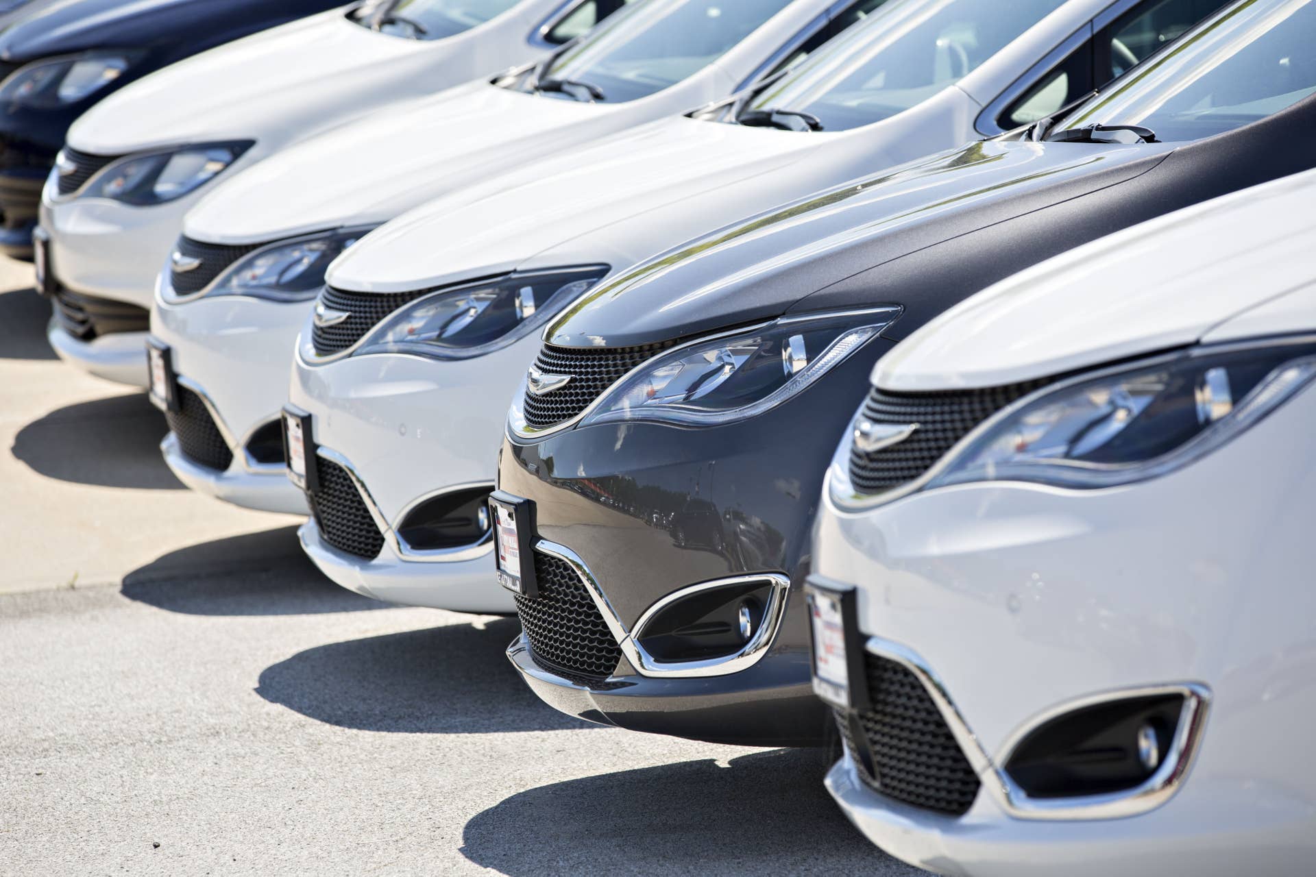 A row of Fiat Chrysler Automobiles (FCA) 2017 Crysler Pacifica minivan vehicles are displayed for sale at a car dealership in Moline, Illinois, U.S., on Saturday, July 1, 2017. Ward's Automotive Group released U.S. monthly total and domestic auto sales figures on July 3. Photographer: Daniel Acker/Bloomberg via Getty Images