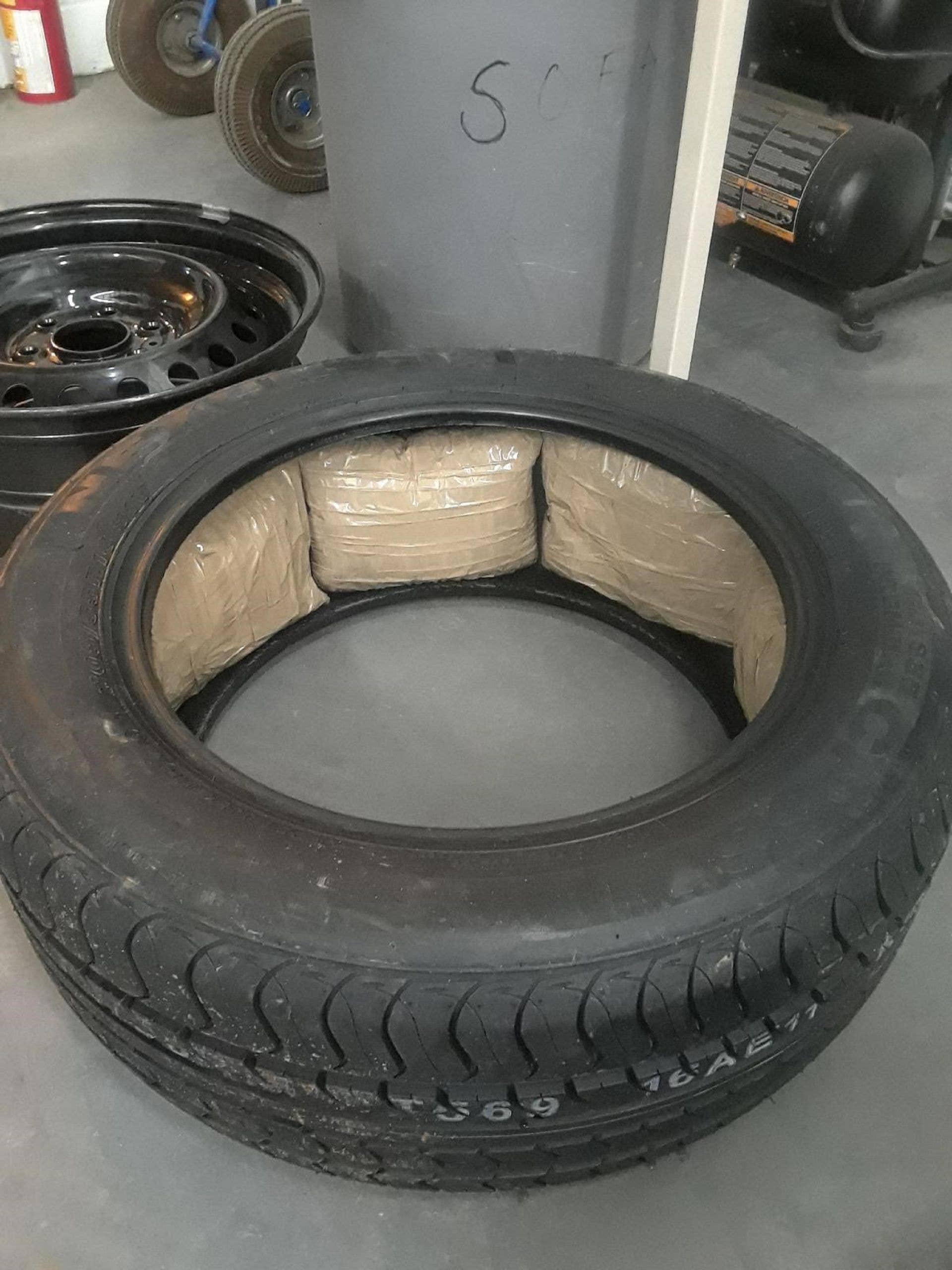 This photo from the Ontario Provincial Police shows illegal drugs smuggled in the spare tire of a Ford Fusion.