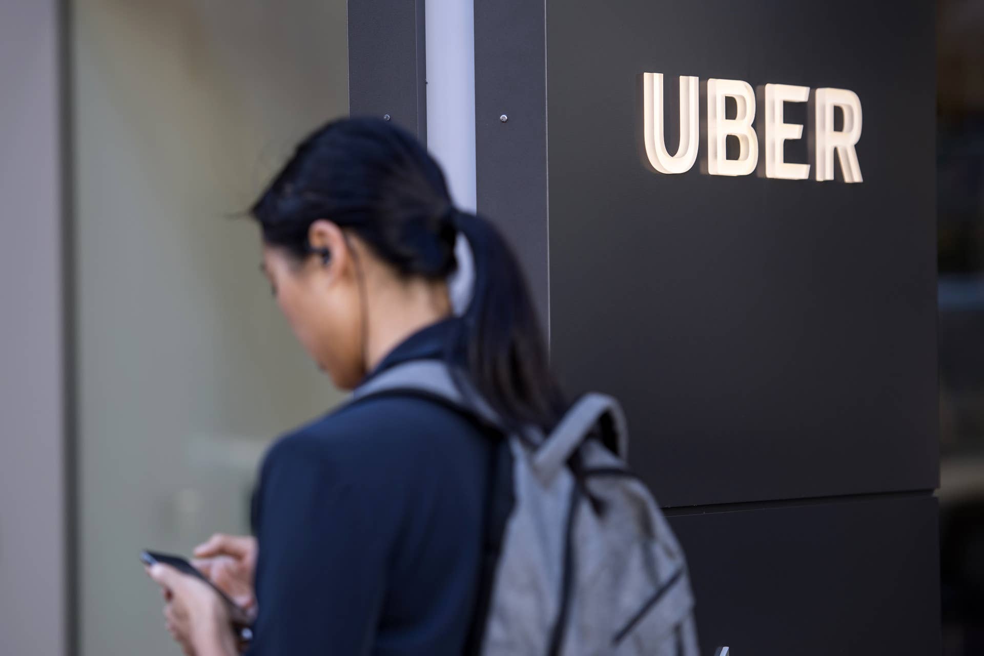 A pedestrian checks a mobile device in front of the Uber Technologies Inc. headquarters building in San Francisco, California, U.S., on Wednesday, June 21, 2017. Travis Kalanick�has resigned from his job leading�Uber Technologies Inc., giving up his effort to hold onto power as a torrent of self-inflicted scandals enveloped him and the global ride-hailing leviathan he co-founded. Photographer: David Paul Morris/Bloomberg via Getty Images
