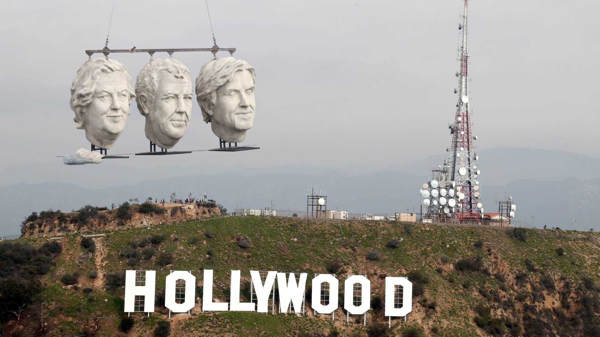LOS ANGELES, CA - JANUARY 18: The Grand Tour - the giant stone heads of British motoring presenters Jeremy Clarkson, James May and Richard Hammond make a dramatic appearance in Los Angeles. Flying past the iconic Hollywood sign before taking to the roads, the latest sighting of the epic statue parts follows sightings in Seattle, Sydney and Amsterdam. The Grand Tour is available now on Amazon Prime Video on January 18, 2017 in Los Angeles, California. (Photo by Todd Williamson/Getty Images for Amazon)