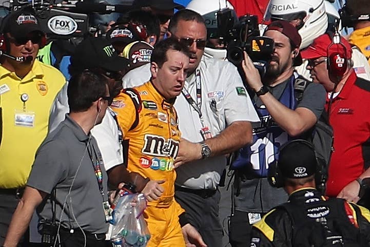 LAS VEGAS, NV - MARCH 12: Kyle Busch, driver of the #18 M&M's Toyota, is escorted away by a NASCAR official after an incident on pit road with Joey Logano (not pictured), driver of the #22 Pennzoil Ford, following the Monster Energy NASCAR Cup Series Kobalt 400 at Las Vegas Motor Speedway on March 12, 2017 in Las Vegas, Nevada. Busch and Logano made contact on the track during the last lap of the race leading to the incident on pit road. (Photo by Chris Graythen/Getty Images)