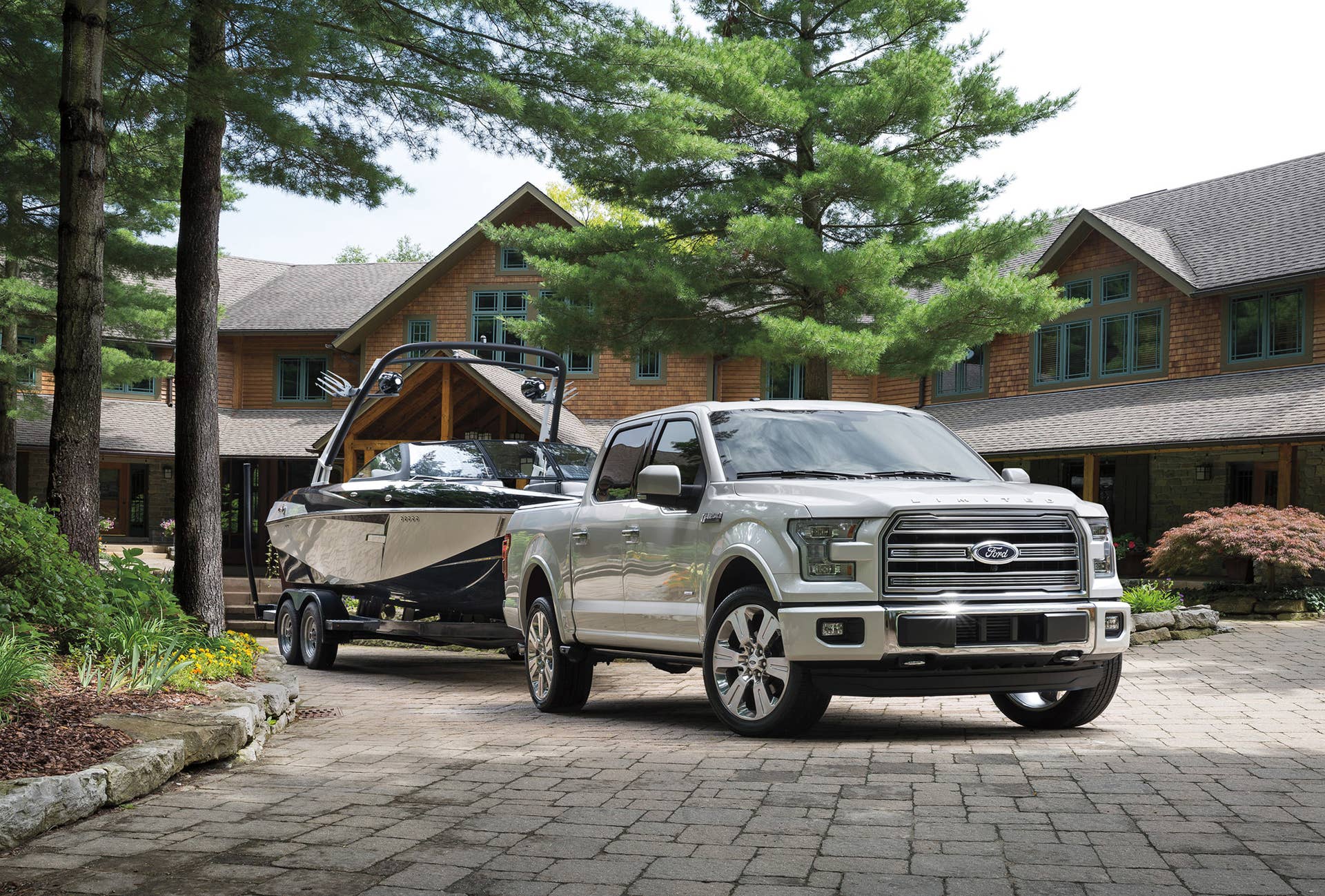 The 2016 Ford F-150 Limited towing a boat, front three-quarter view.