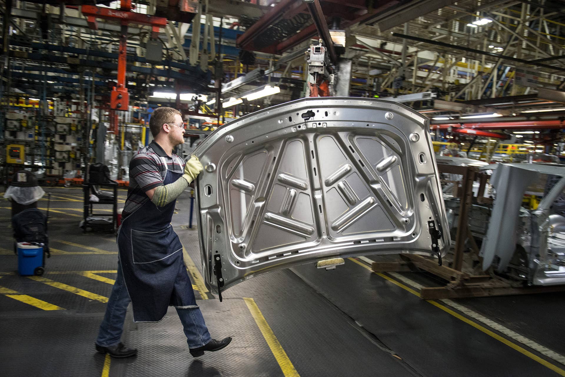 An employee prepares to install the hood on a sports utility vehicle (SUV) at the General Motors Co. (GM) assembly plant in Arlington, Texas, U.S., on Thursday, March 10, 2016. The U.S. Census Bureau is scheduled to release business inventories figures on March 15. Photographer: Matthew Busch/Bloomberg via Getty Images