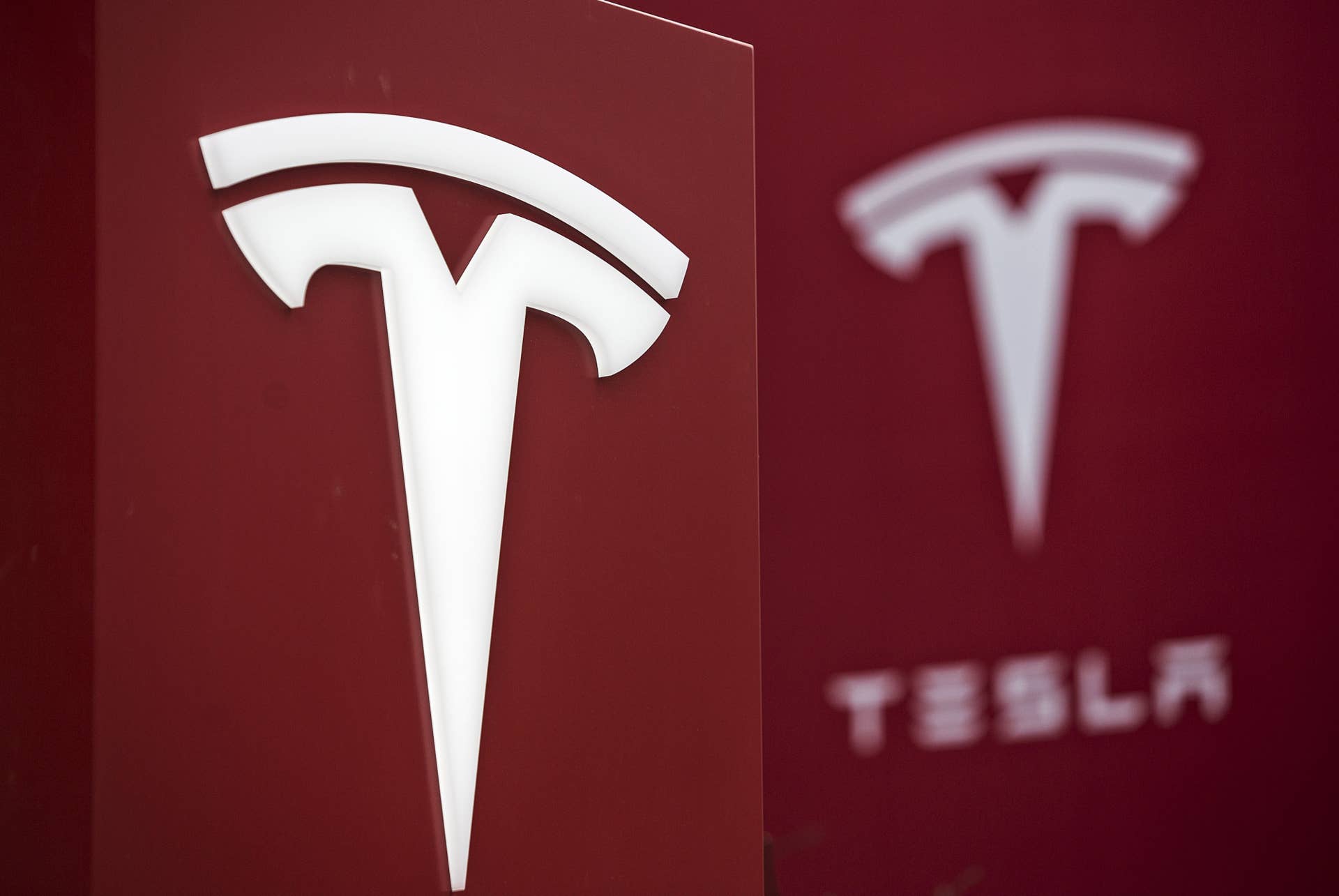 Tesla Motors Inc. logo is displayed at one of the company's electric charging stations near a shopping mall in Beijing, China, on Wednesday, March 9, 2016. While air pollution in the nation's capital has improved slightly, residents still frequently don face masks to filter the smog, including during a string of days recently air quality was listed as hazardous. Photographer: Qilai Shen/Bloomberg via Getty Images