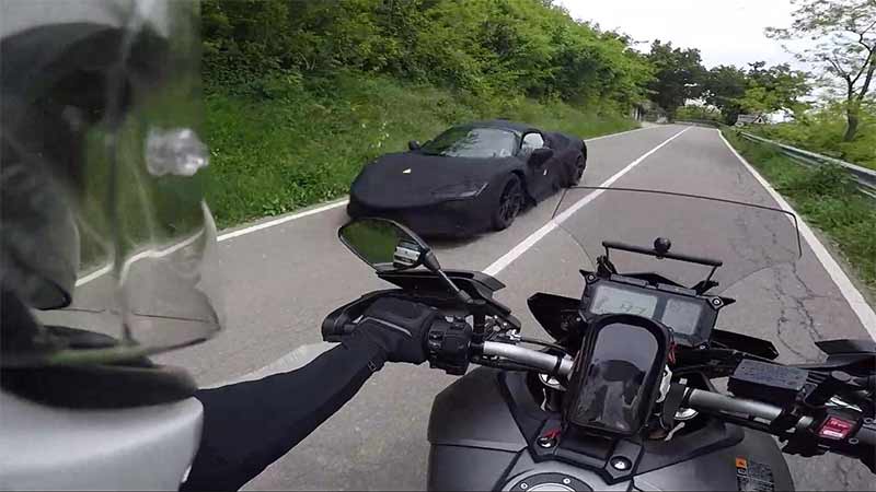 A motorcyclist captures a prototype mid-engined hybrid Ferrari on roads around Maranello