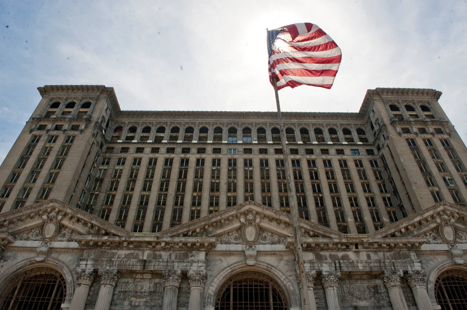 DETROIT, MI - MAY 02: The American flag flies at the entrance of the abandoned Michigan Central Station on May 2, 2013 in Detroit, Michigan. The station was opened in 1913, closed in 1988, and has fallen into disrepair since. (Photo by Ann Hermes/The Christian Science Monitor via Getty Images)