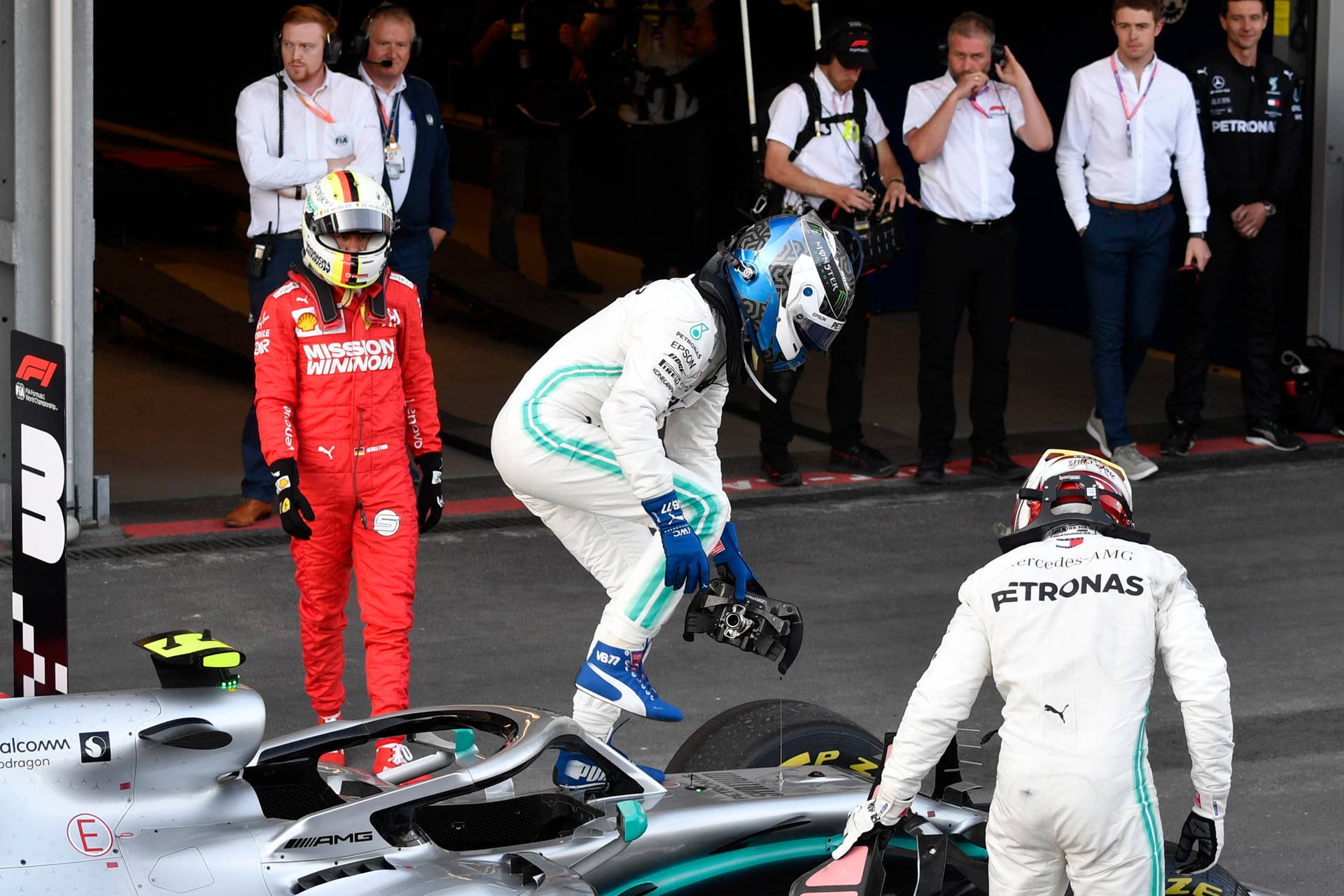 Winner Mercedes' Finnish driver Valtteri Bottas (C) gets out of his car next to second placed Mercedes' British driver Lewis Hamilton and third placed Ferrari's German driver Sebastian Vettel after the Formula One Azerbaijan Grand Prix at the Baku City Circuit in Baku on April 28, 2019. (Photo by Alexander NEMENOV / AFP) (Photo credit should read ALEXANDER NEMENOV/AFP/Getty Images)