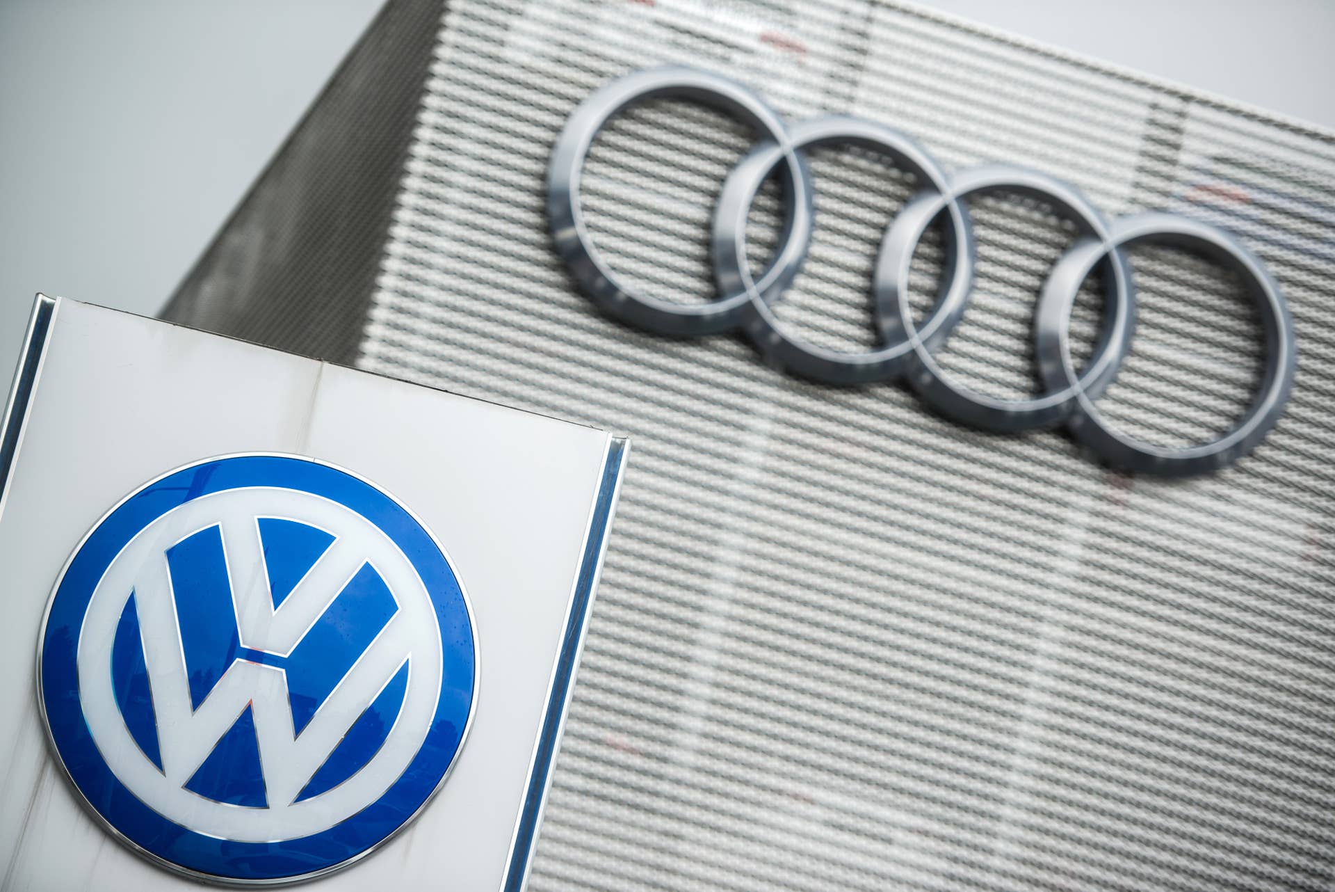 The logos of Volkswagen AG (VW), left, and Audi AG sit outside an automobile dealership in Vienna, Austria, on Thursday, Oct. 8, 2015. Volkswagen AG will probably start recalling diesel cars with rigged emissions systems in January and plans to complete the repairs by the end of 2016. Photographer: Akos Stiller/Bloomberg via Getty Images