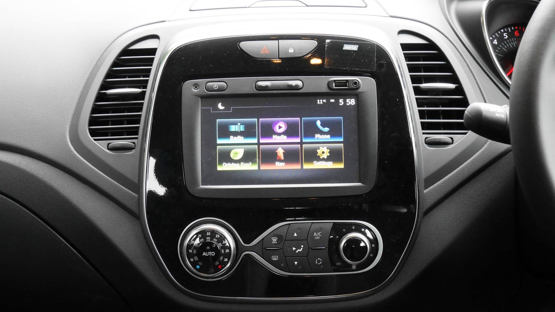 Push-button volume control. USB port and aux jack above the touchscreen. Mon dieu.