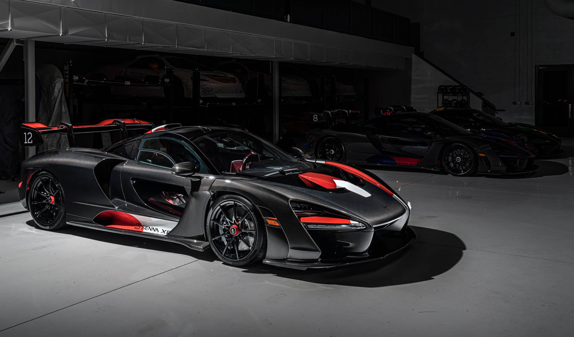 Each car gets a name and celebrates a Formula 1 race track where Ayrton Senna scored an especially outstanding victory. All three are dressed in gloss black carbon fiber, accented with the colors of the F1 circuit's country, and adorned with Ayrton's car number on the wing endplates.
