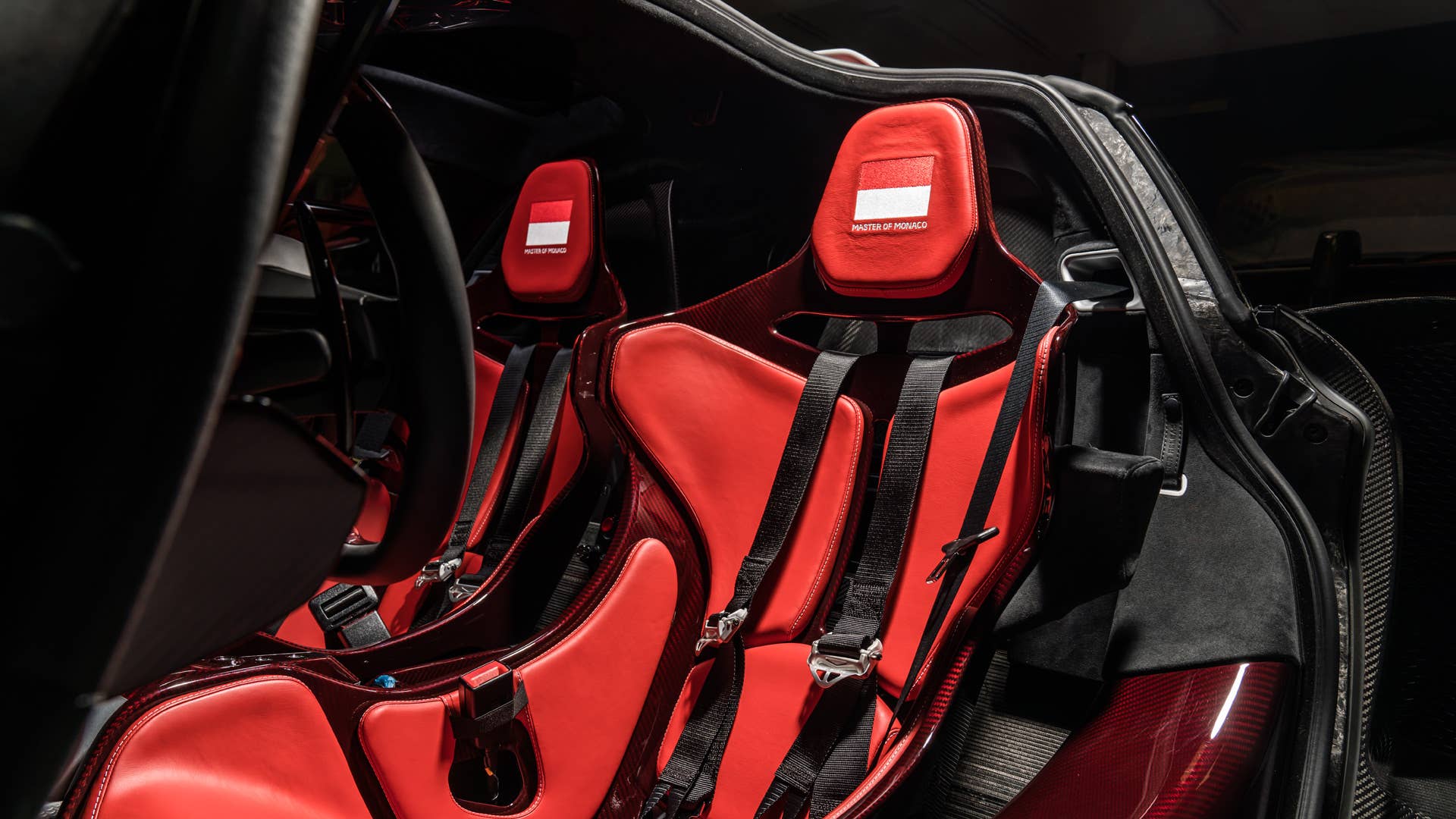 Each car gets a name and celebrates a Formula 1 race track where Ayrton Senna scored an especially outstanding victory. All three are dressed in gloss black carbon fiber, accented with the colors of the F1 circuit's country, and adorned with Ayrton's car number on the wing endplates.