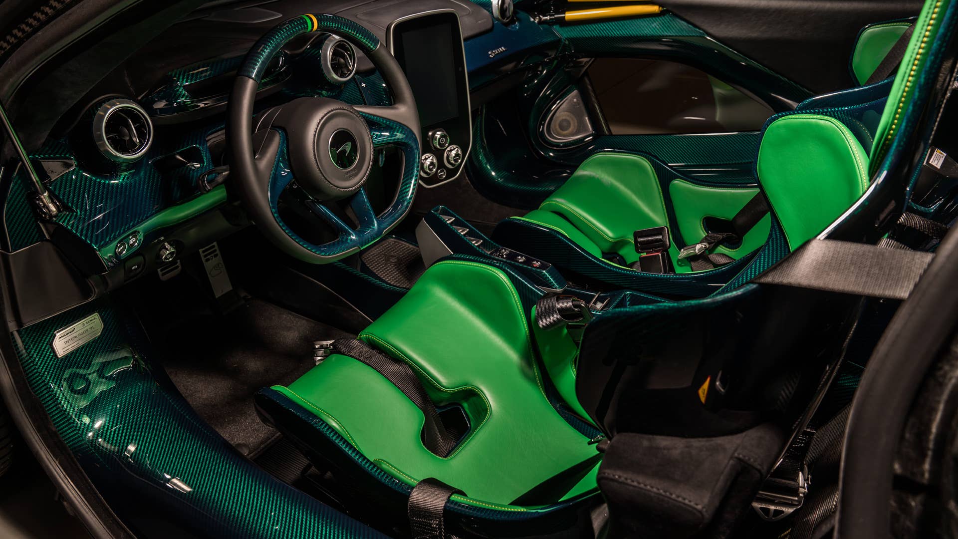 Each car gets a name and celebrates a Formula 1 race track where Ayrton Senna scored an especially outstanding victory. All three are dressed in gloss black carbon fiber, accented with the colors of the F1 circuit's country, and adorned with Ayrton's car number on the wing endplates.