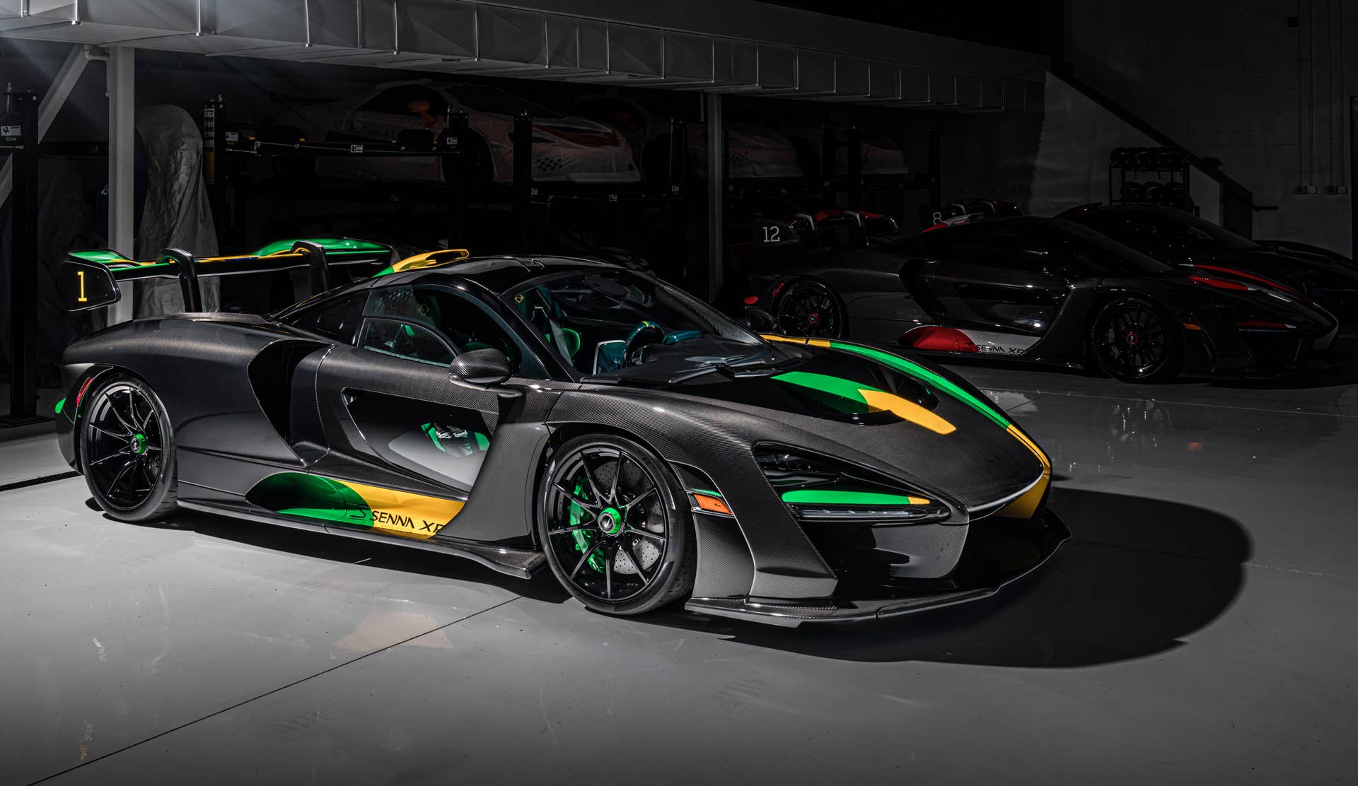 Each car gets a name and celebrates a Formula 1 race track where Ayrton Senna scored an especially outstanding victory. All three are dressed in gloss black carbon fiber, accented with the colors of the F1 circuit's country, and adorned with Ayrton's car number on the wing endplates.