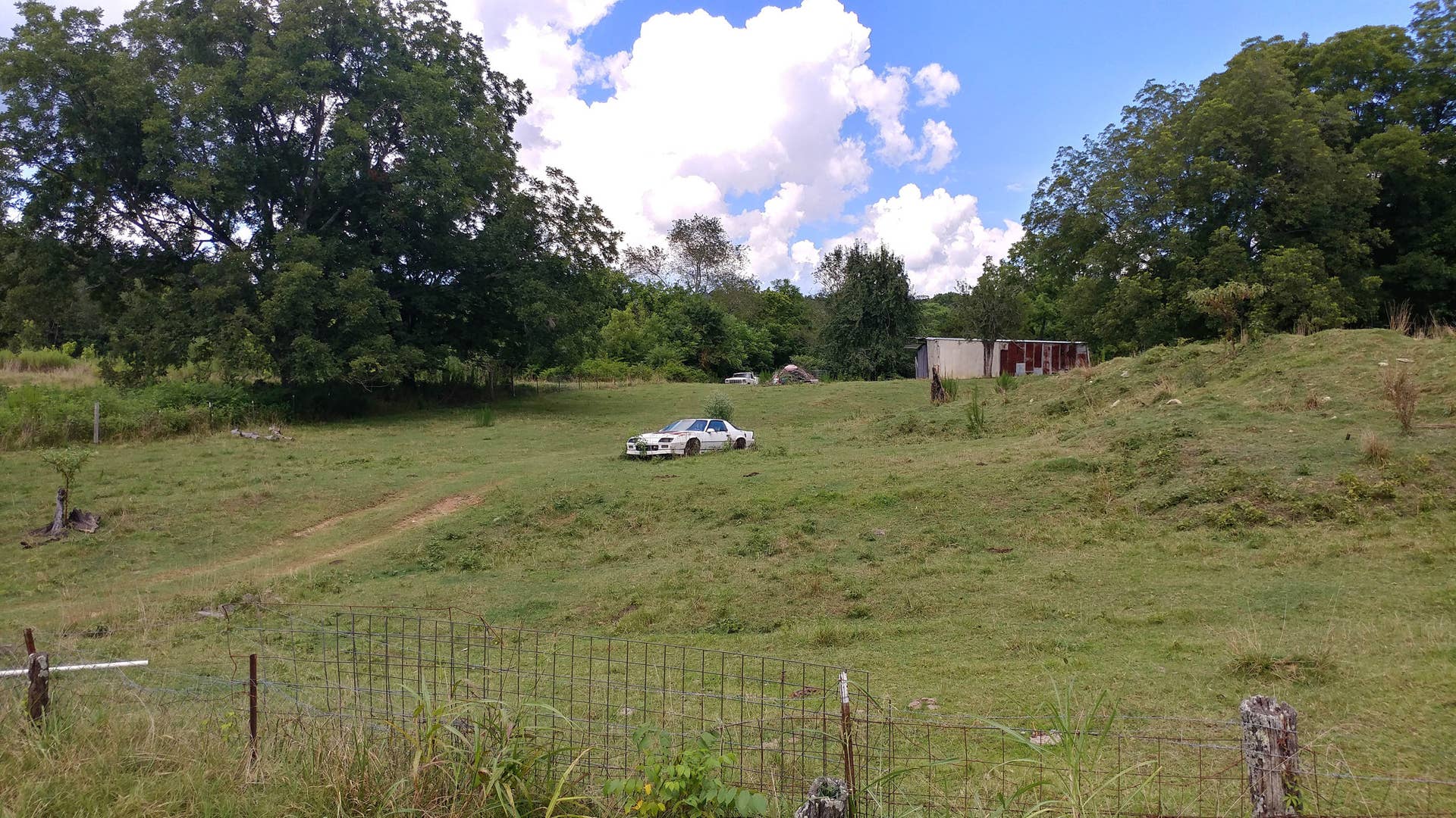 Someone placed that car there, and continues to mow around it to make sure it looks good. Good-ish.