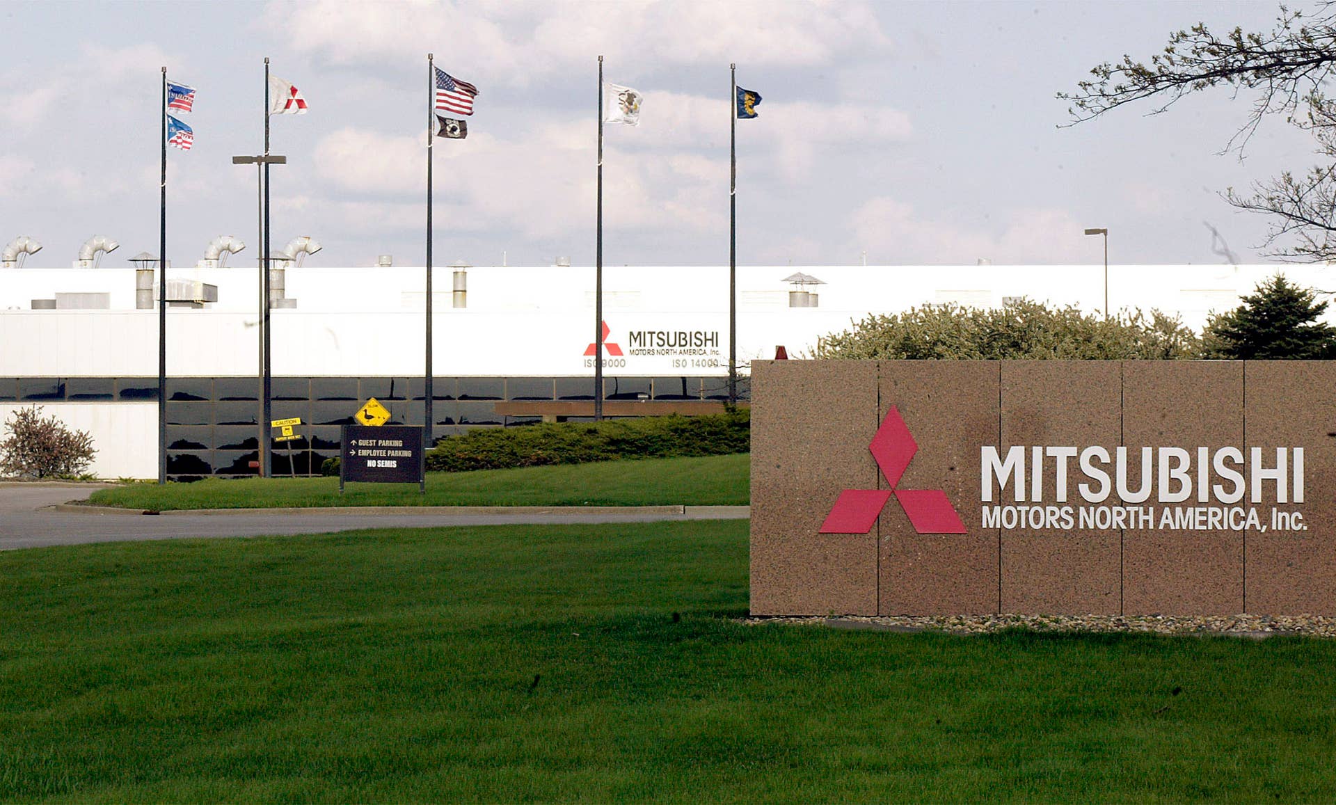 UNITED STATES - APRIL 26: Flags fly outside of the Mitsubishi Motors plant in Normal, Illinois, Monday, April 26, 2004. Japan's only unprofitable automaker will eliminate 1,200 jobs, or 38 percent of the 3,150 positions at its Normal, Illinois, factory, the Tokyo-based company's U.S. unit said in a statement. (Photo by Frank Polich/Bloomberg via Getty Images)
