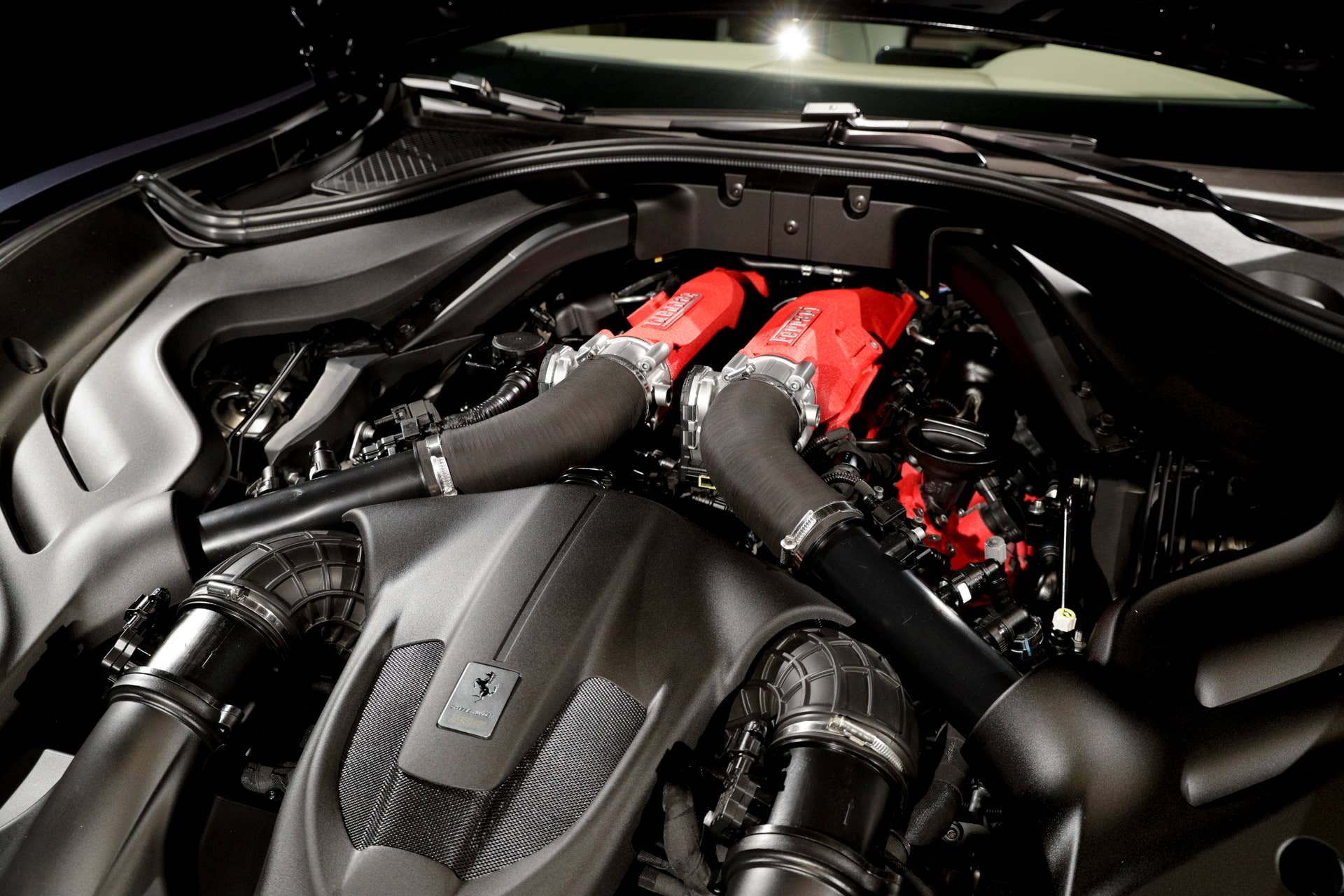 A view of the engine of the Ferrari Roma car that was unveiled in Rome, Thursday, Nov. 14, 2019. Ferrari unveils a new sports coupe aimed at enticing entry-level buyers and competing with the Porsche 911, part of a complete refresh of its model lineup by 2022. (AP Photo/Gregorio Borgia)