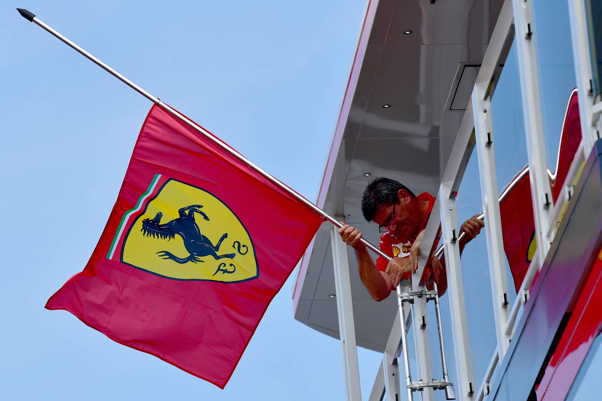 A man fixes a Scuderia Ferrari flag at half-staff for the death of former Chief Executive of Fiat-Chrysler and Chairman of Ferrari Sergio Marchionne ahead of the Formula One Hungarian Grand Prix at the Hungaroring circuit in Mogyorod near Budapest, Hungary, on July 27, 2018. (Photo by ANDREJ ISAKOVIC / AFP) (Photo credit should read ANDREJ ISAKOVIC/AFP/Getty Images)
