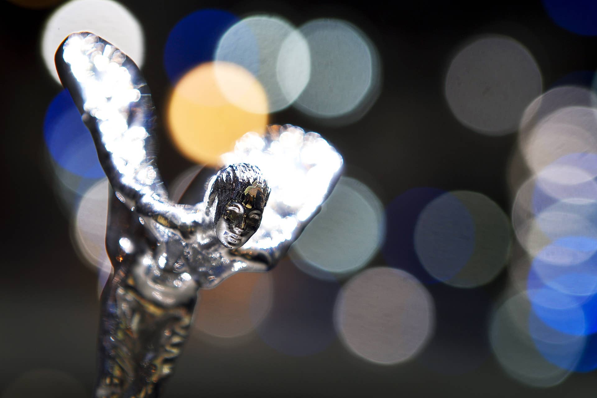 The Rolls-Royce's iconic mascot 'the Spirit of Ecstacy' is pictured in front of a screen on the bonnet of the new Rolls Royce Wraith model car displayed as World premiere at the British carmaker's booth on March 6, 2013 on the press day of Geneva car Show, in Geneva. The top luxury segment, the Geneva show's main specialty, appeared oblivious to the crisis meanwhile. The European crisis hovered like a dark cloud over the Geneva International Motor Show, but there was no lack of new luxury cars shining on the showroom floor. McLaren, Ferrari and Lamborghini all unveiled so-called supercars to be sold for between one to three million euros ($1.3 - $3.9 million). AFP PHOTO / FABRICE COFFRINI (Photo credit should read FABRICE COFFRINI/AFP/Getty Images)