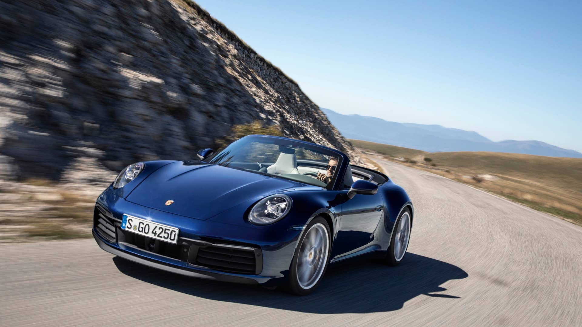 The Porsche 992 911 4S Cabriolet on a sunny seaside road.
