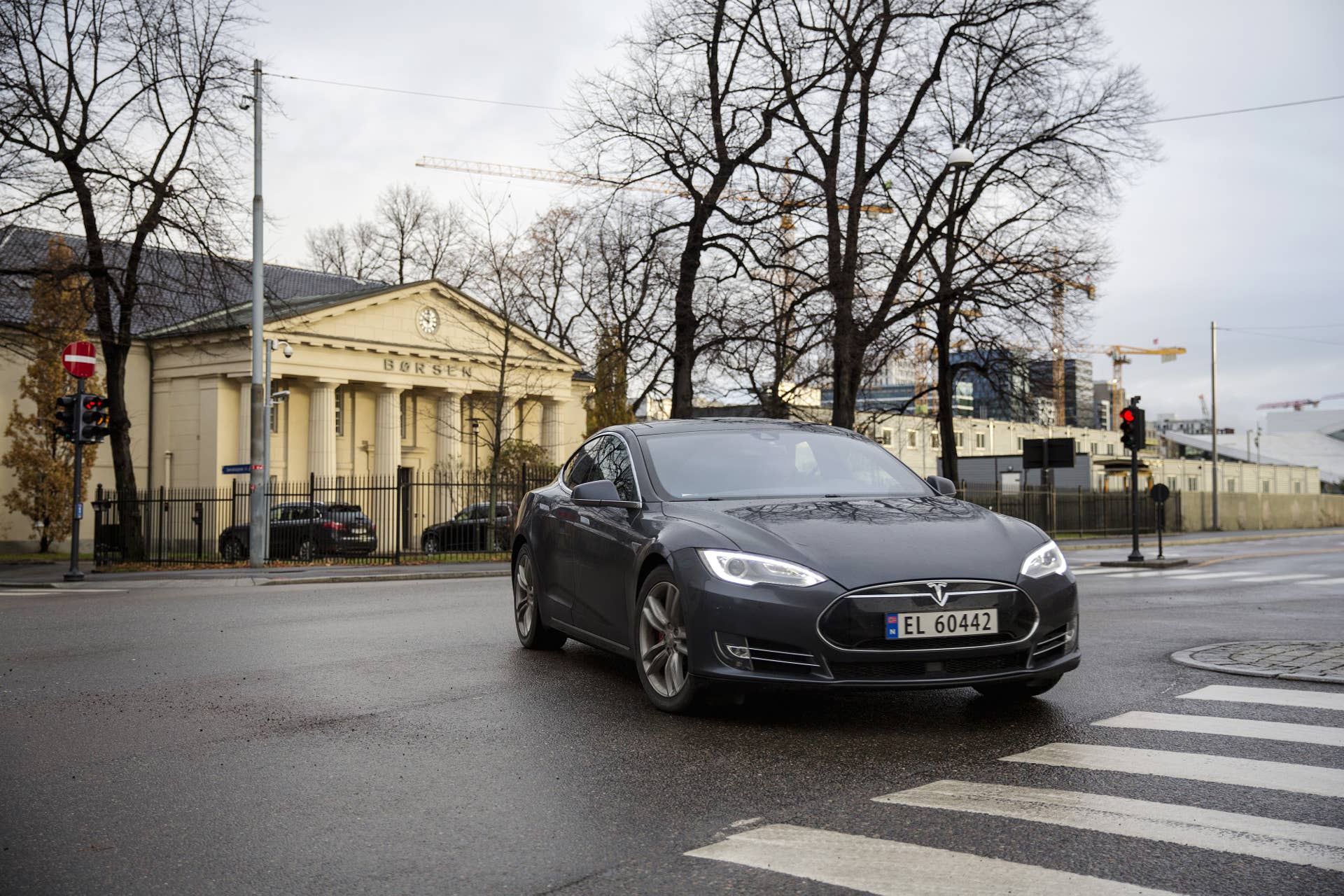 A Tesla Motors Inc. Model S electric vehicle (EV) drives past the Oslo Stock Exchange in Oslo, Norway, on Monday, Nov. 21, 2016. The International Energy Agency forecasts that global gasoline consumption has all but peaked as more efficient cars and the advent of electric vehicles from new players such as Tesla Motors Inc. halt demand growth in the next 25 years. Photographer: Fredrik Bjerknes/Bloomberg via Getty Images