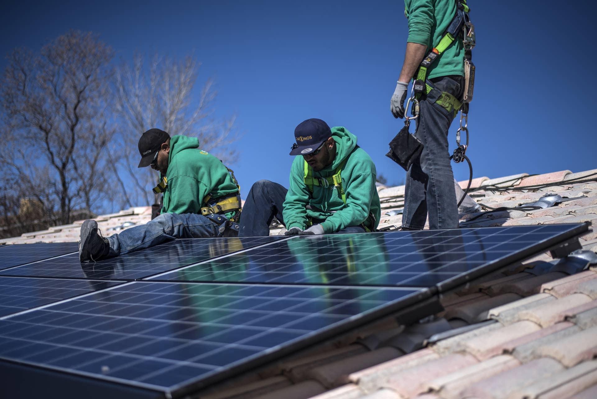 Workers secure solar panels to a rooftop during a SolarCity Corp. residential installation in Albuquerque, New Mexico, U.S., on Monday, Feb. 8, 2016. SolarCity is scheduled to release earnings figures on February 9. Photographer: Sergio Flores/Bloomberg via Getty Images