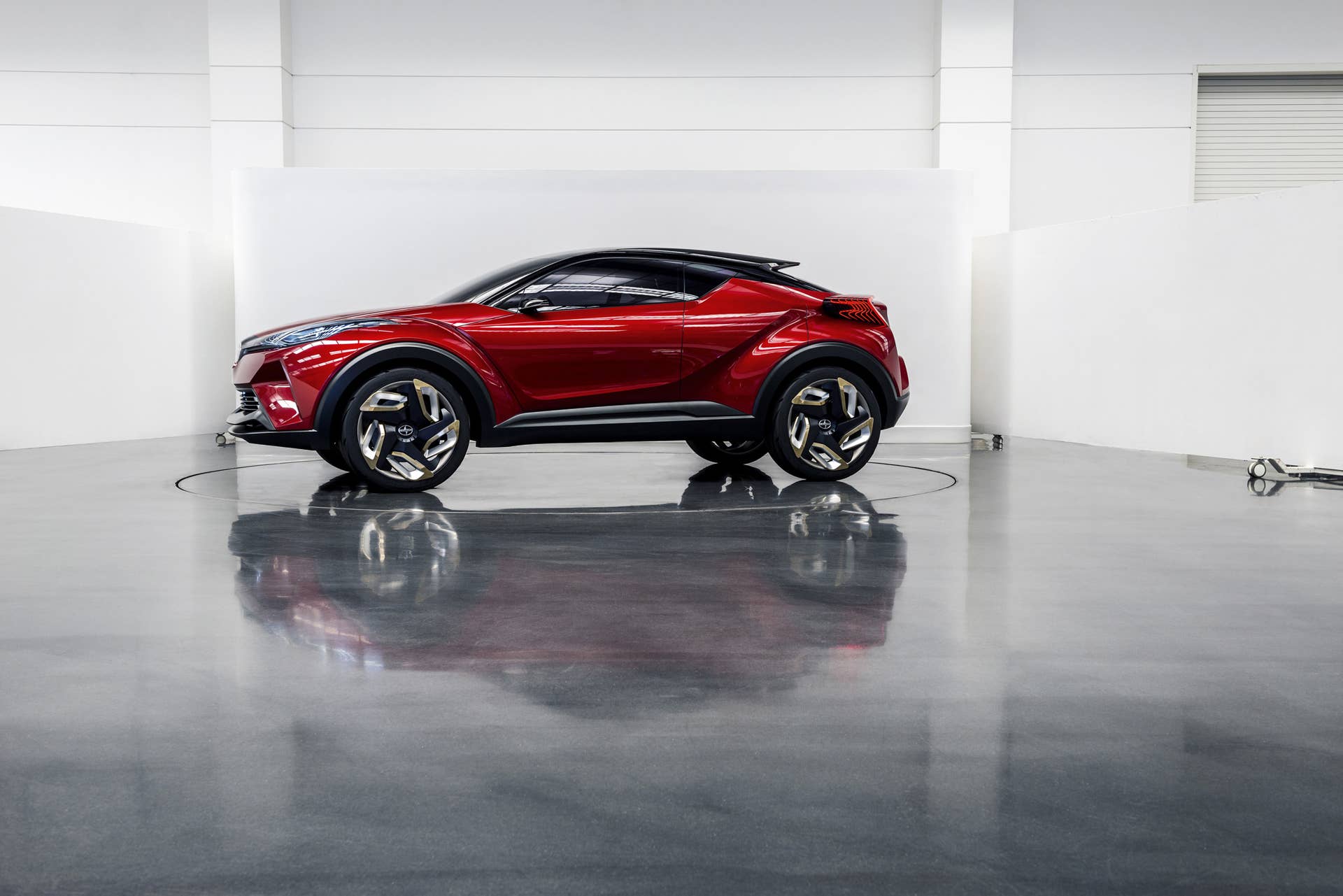 The Scion C-HR concept shown off in red for the LA Auto Show, side view indoor.