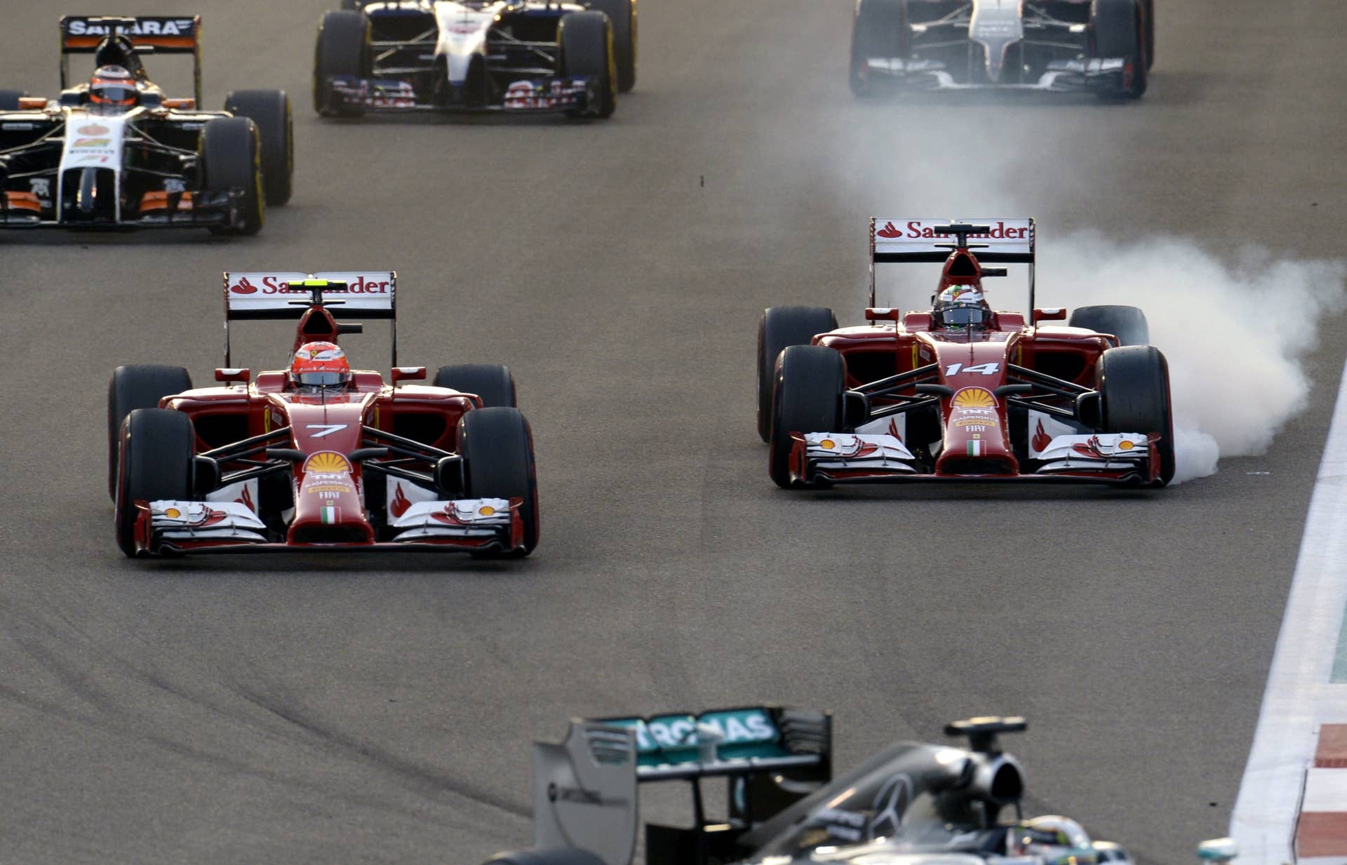 Ferrari's Spanish driver Fernando Alonso (R) breaks hard beside team mate Ferrari's Finnish driver Kimi Raikkonen after the start of the of the Abu Dhabi Formula One Grand Prix at the Yas Marina circuit on November 23, 2014.  AFP PHOTO / TOM GANDOLFINI        (Photo credit should read Tom Gandolfini/AFP/Getty Images)