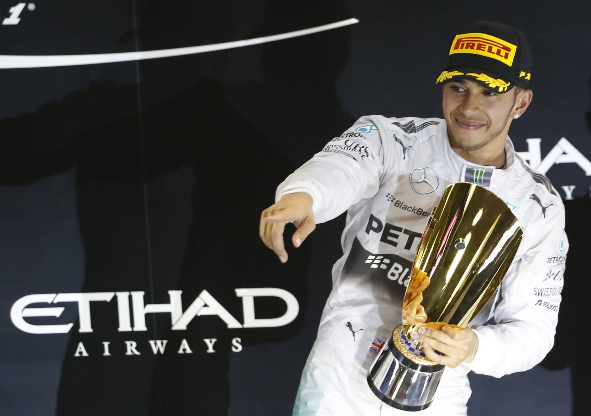 Mercedes-AMG's British driver  Lewis Hamilton celebrates on the podium at the Yas Marina circuit in Abu Dhabi on November 23, 2014 after the Abu Dhabi Formula One Grand Prix.     AFP PHOTO / KARIM SAHIB        (Photo credit should read KARIM SAHIB/AFP/Getty Images)