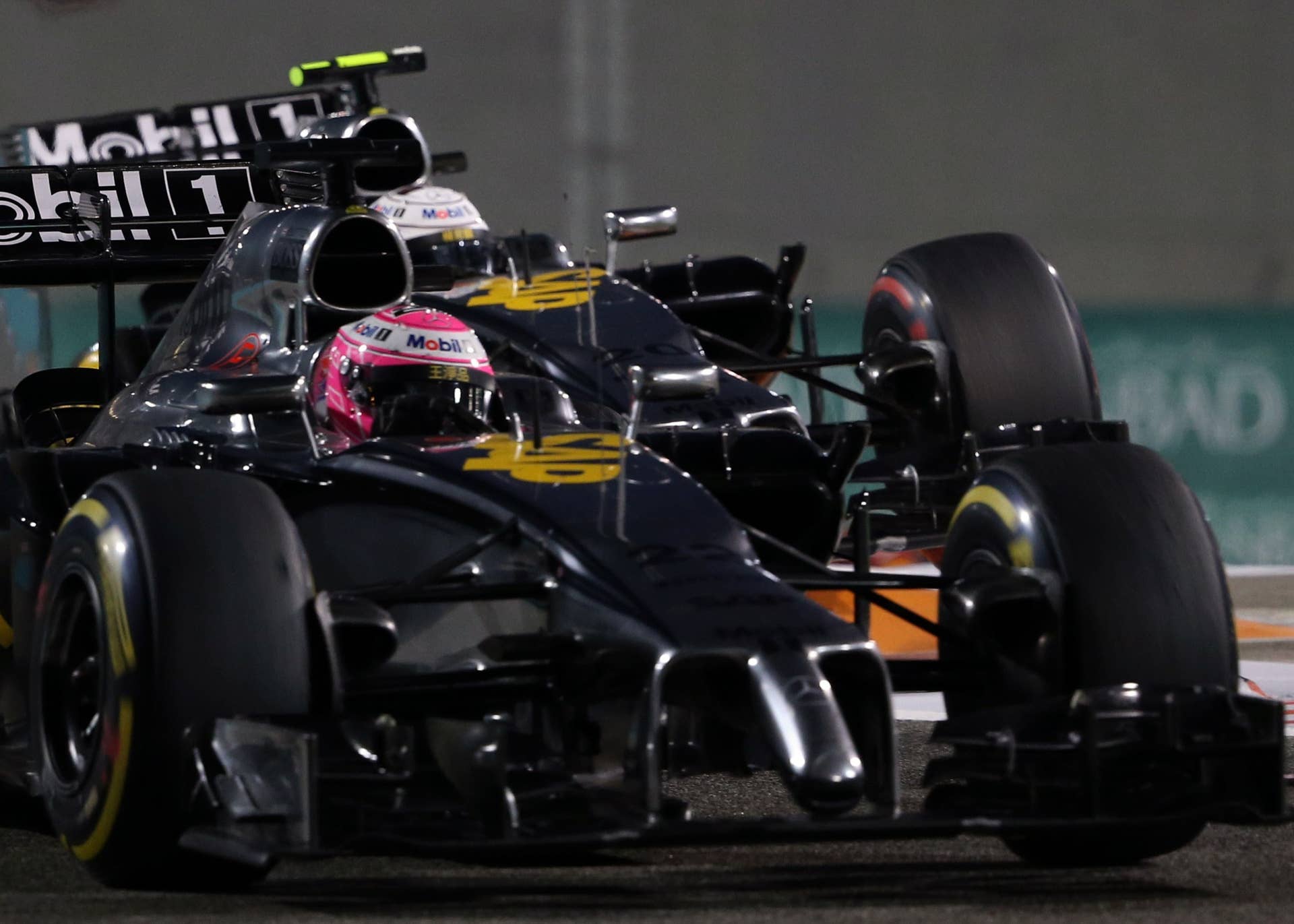 McLaren Mercedes'  British driver  Jenson Button (l) and McLaren Mercedes'  Danish driver  Kevin Magnussen  clash during the Abu Dhabi Formula One Grand Prix at the Yas Marina circuit on November 23, 2014.  AFP PHOTO / PATRICK BAZ        (Photo credit should read PATRICK BAZ/AFP/Getty Images)