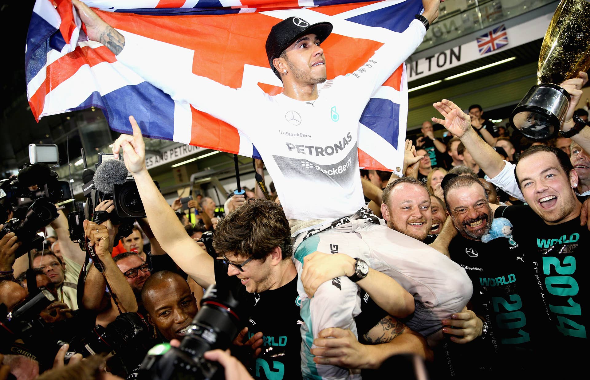 ABU DHABI, UNITED ARAB EMIRATES - NOVEMBER 23:  Lewis Hamilton of Great Britain and Mercedes GP celebrates with his team after winning the World Championship after the Abu Dhabi Formula One Grand Prix at Yas Marina Circuit on November 23, 2014 in Abu Dhabi, United Arab Emirates.  (Photo by Clive Mason/Getty Images)