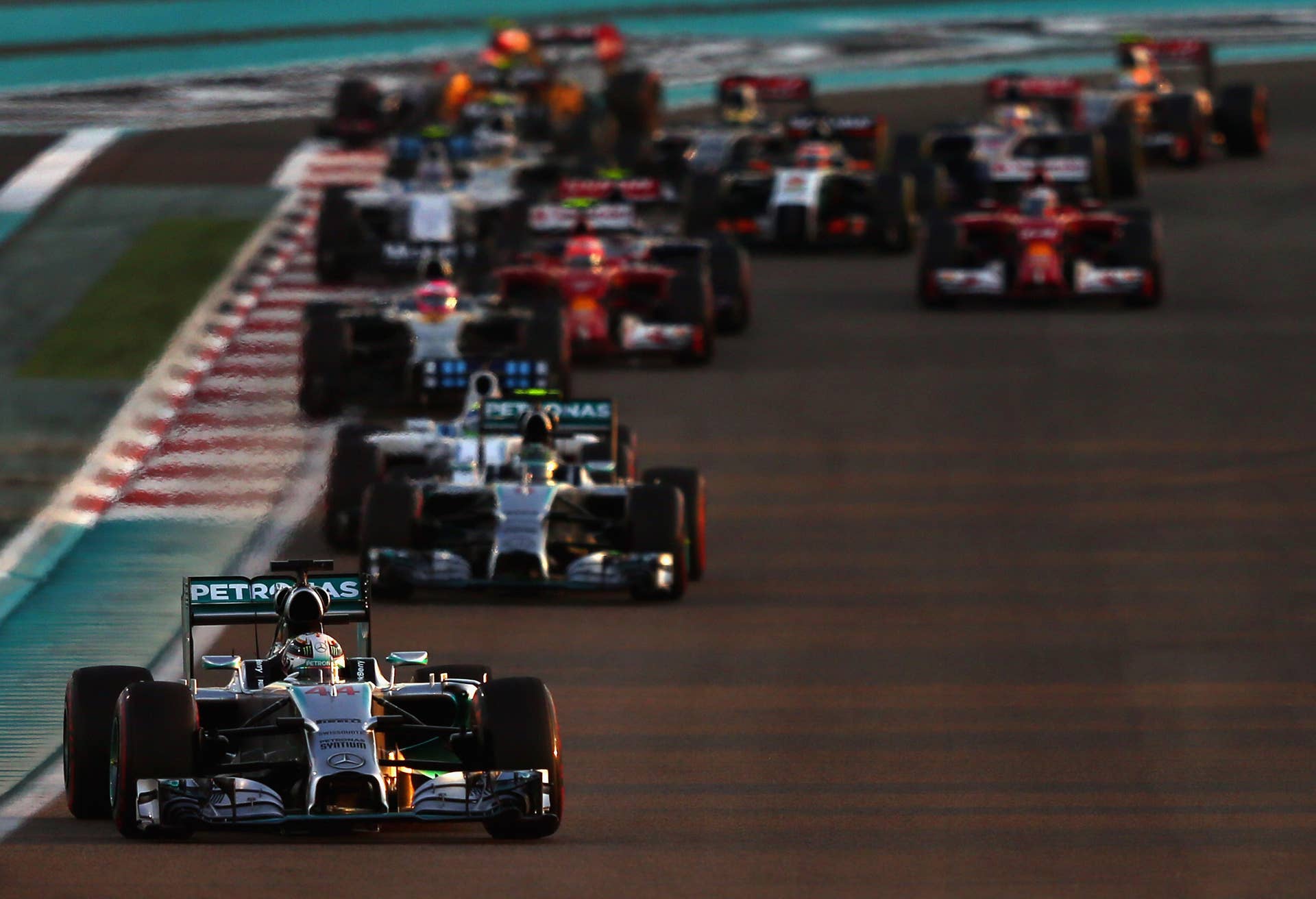 ABU DHABI, UNITED ARAB EMIRATES - NOVEMBER 23:  Lewis Hamilton of Great Britain and Mercedes GP leads the field on the opening lap of the Abu Dhabi Formula One Grand Prix at Yas Marina Circuit on November 23, 2014 in Abu Dhabi, United Arab Emirates.  (Photo by Dan Istitene/Getty Images)