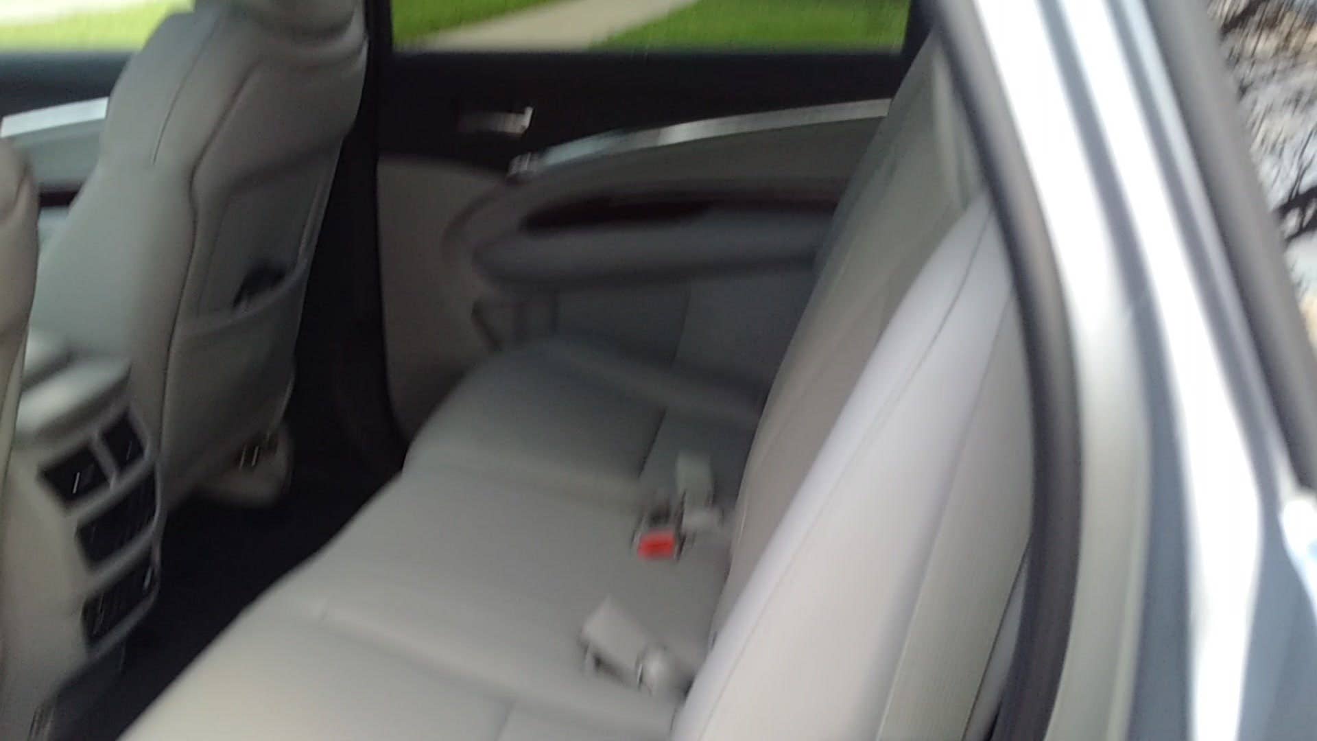 Editor in Chief Mike Austin demonstrates the power fold-and-slide second row seats in the Acura MDX