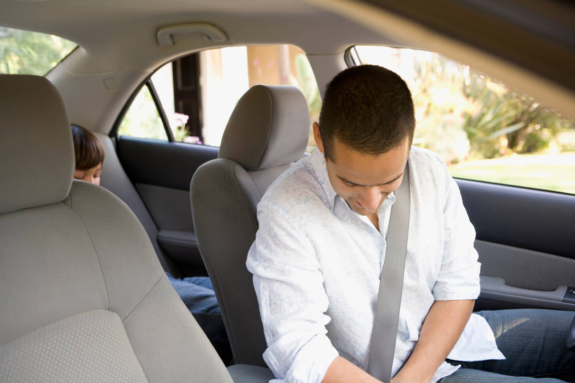 Man buckling seat belt in car