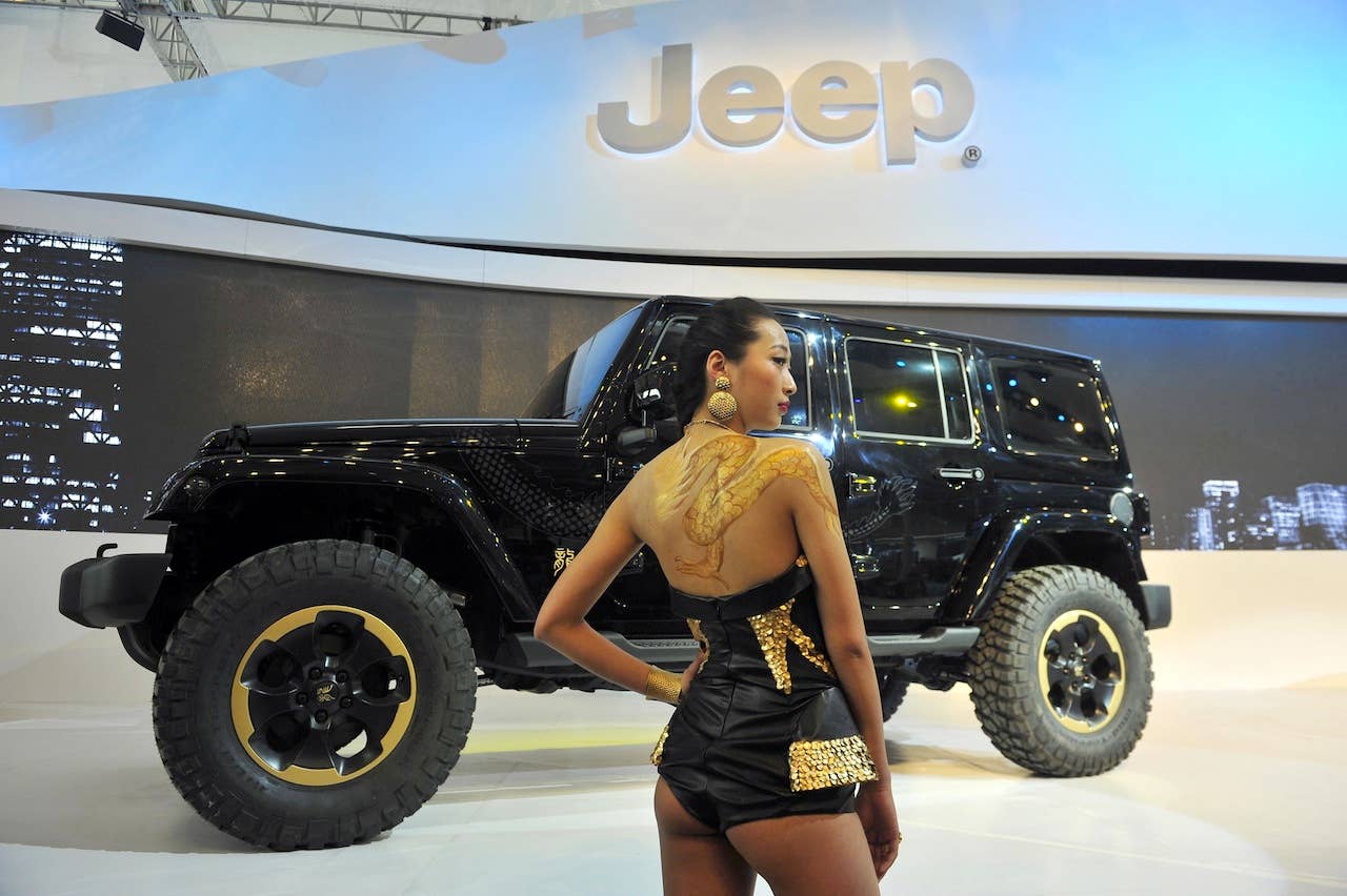 A model poses with the latest Jeep on display at the Auto China 2012 exhibition, which will run until May 2 and see the worldwide launch of 120 new models, 36 of them from international brands in Beijing on April 22, 2012. Major carmakers gathered in Beijing for China's leading auto show, seeking an edge in the world's largest automobile market after a sharp slowdown in growth. CHINA OUT AFP PHOTO (Photo credit should read STR/AFP/Getty Images)
