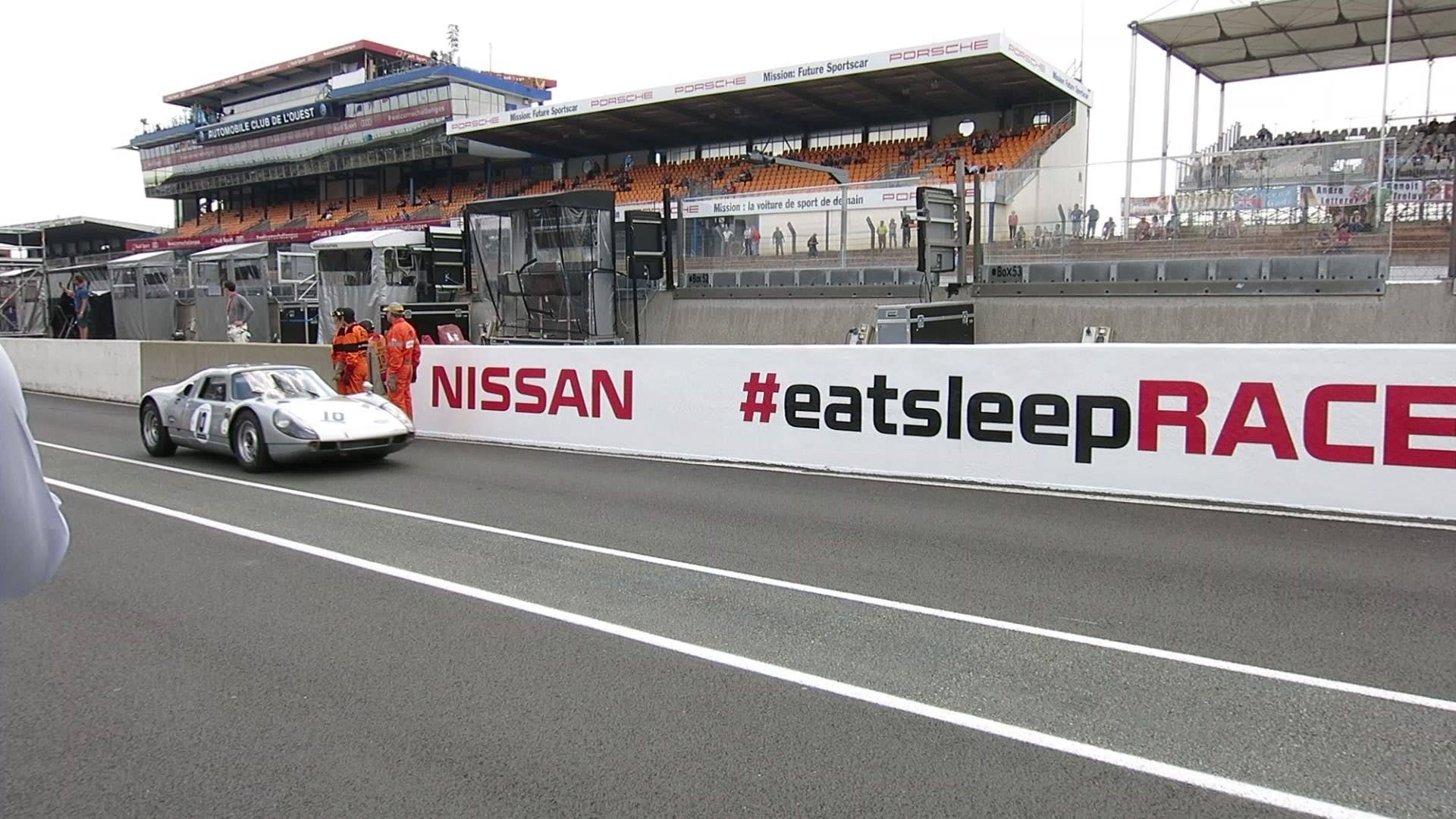 Legendary classic racecars exit the pit lane and head out for qualifying at Le Mans.