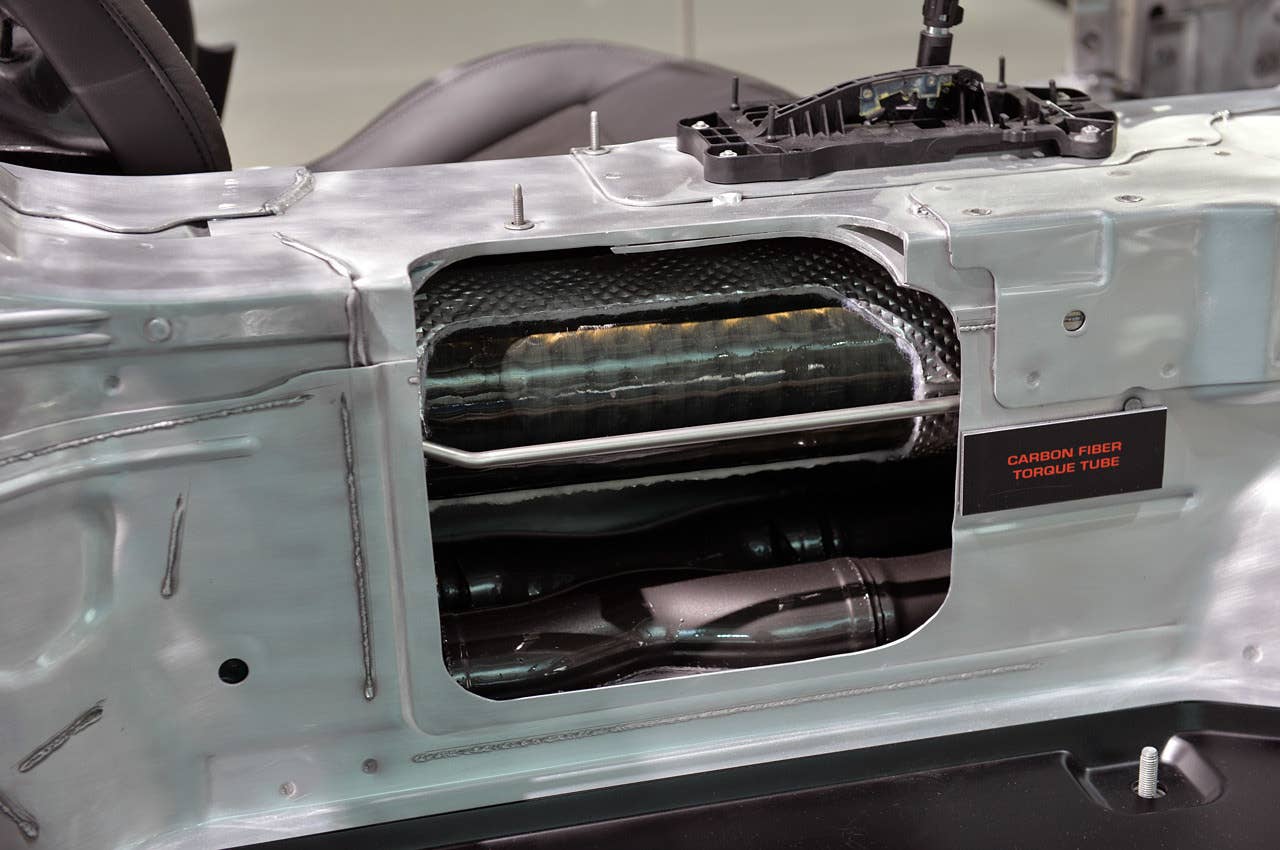 The center tunnel has been cut open to reveal the carbon-fiber torque tube and driveshaft. While many other automakers have carbon-fiber driveshafts, Chevrolet is one of the first to utilize the material for its torque tube (the Stingray uses steel). The shifter mechanism, extending into the cabin, is seen at the top of the casing, with the twin exhaust pipes running below it (the torque tube is insulated from the heat with an aluminized wrap.)