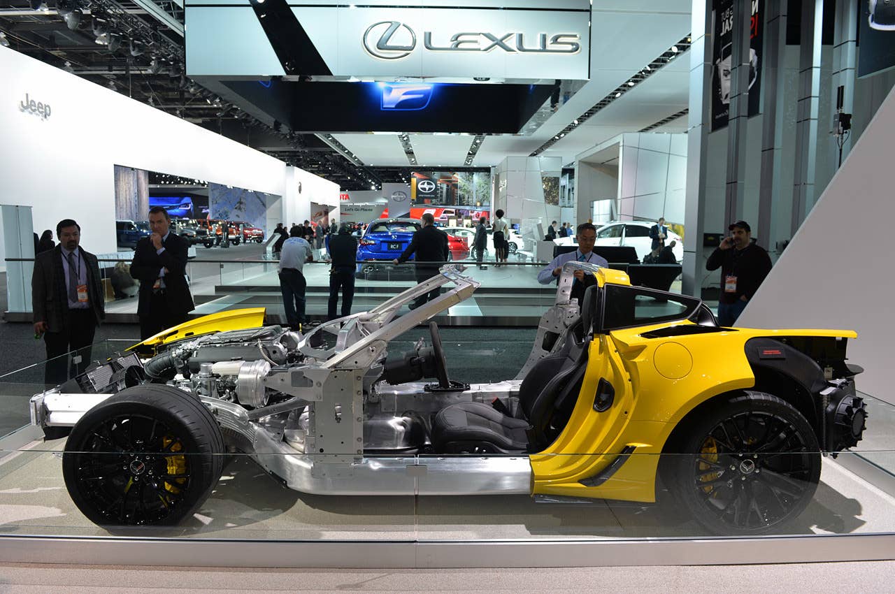 A clean side view of the C7 Corvette Z06. The extensive use of aluminum is evident, as the composite skin has been pulled back to the middle of the driver's door to reveal the bright, lightweight corrosion-resistant alloy. Note that the mass of the LT4 V8 engine is set very low and behind the front wheels — this configuration improves balance that pays dividends in the handling department.
